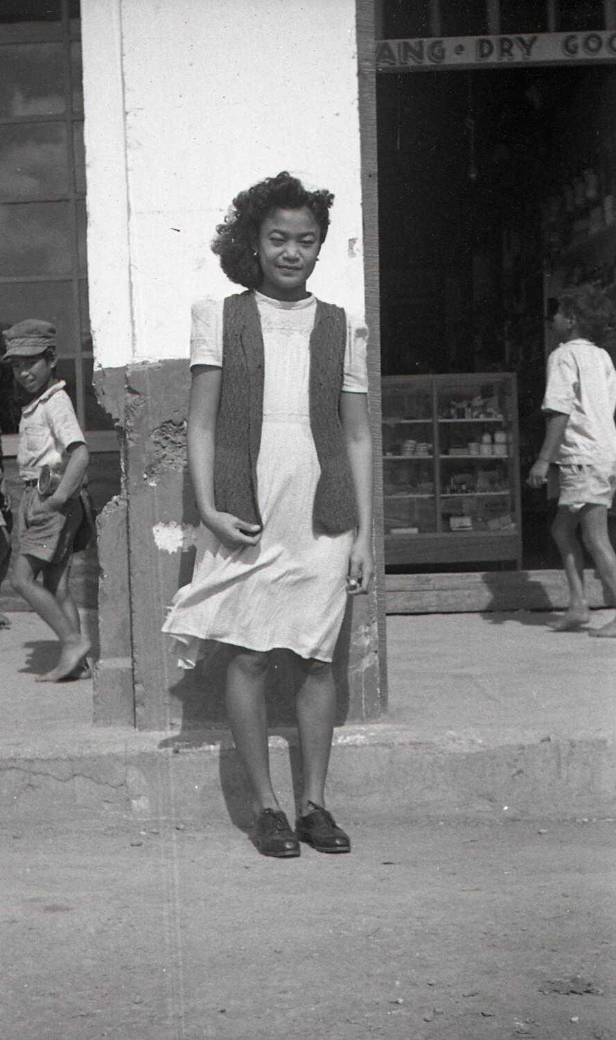 Young Filipina Woman Outside a Dry Goods Store, Luzon, Philippines, WWII Era