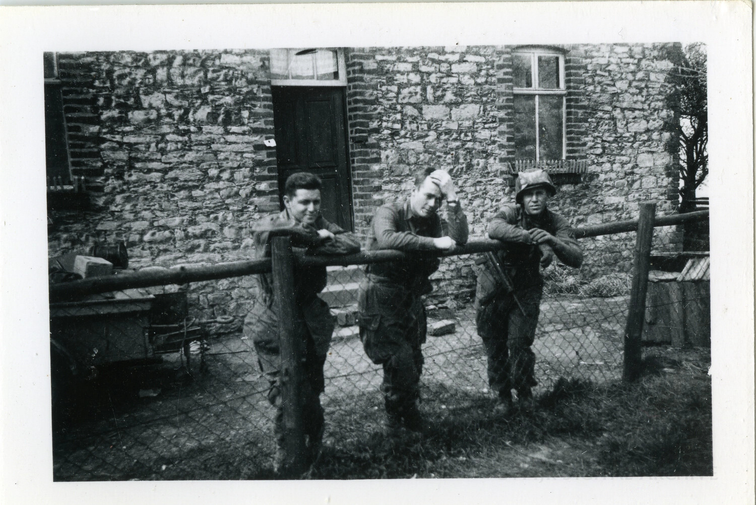 Three Soldiers at a Farmhouse Fence Rail, Ardennes Region, 1944-1945