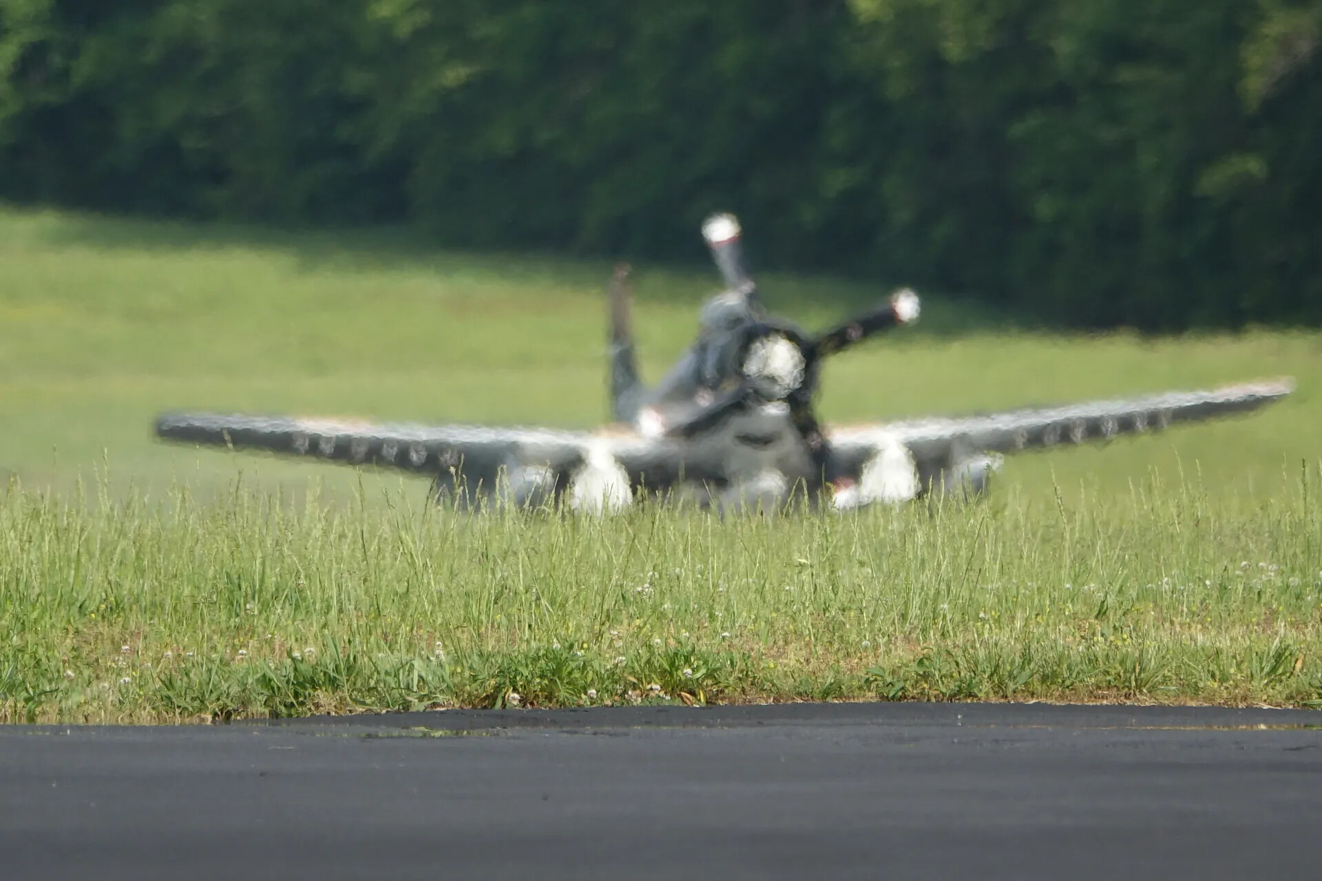 Out-of-Focus View of Radial-Engine Warbird (Likely A-1 Skyraider) on Airfield Grass