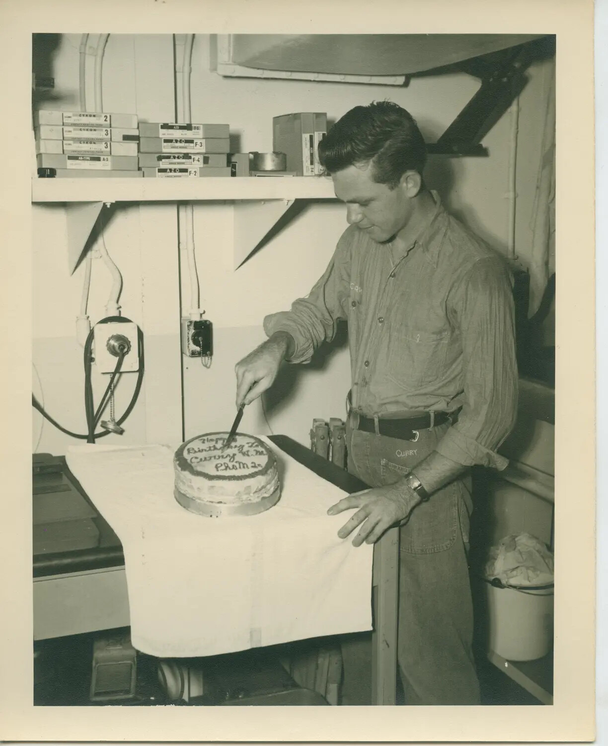Sailor Cutting Birthday Cake in Ship's Photo Lab, USS Petrof Bay (CVE-80)