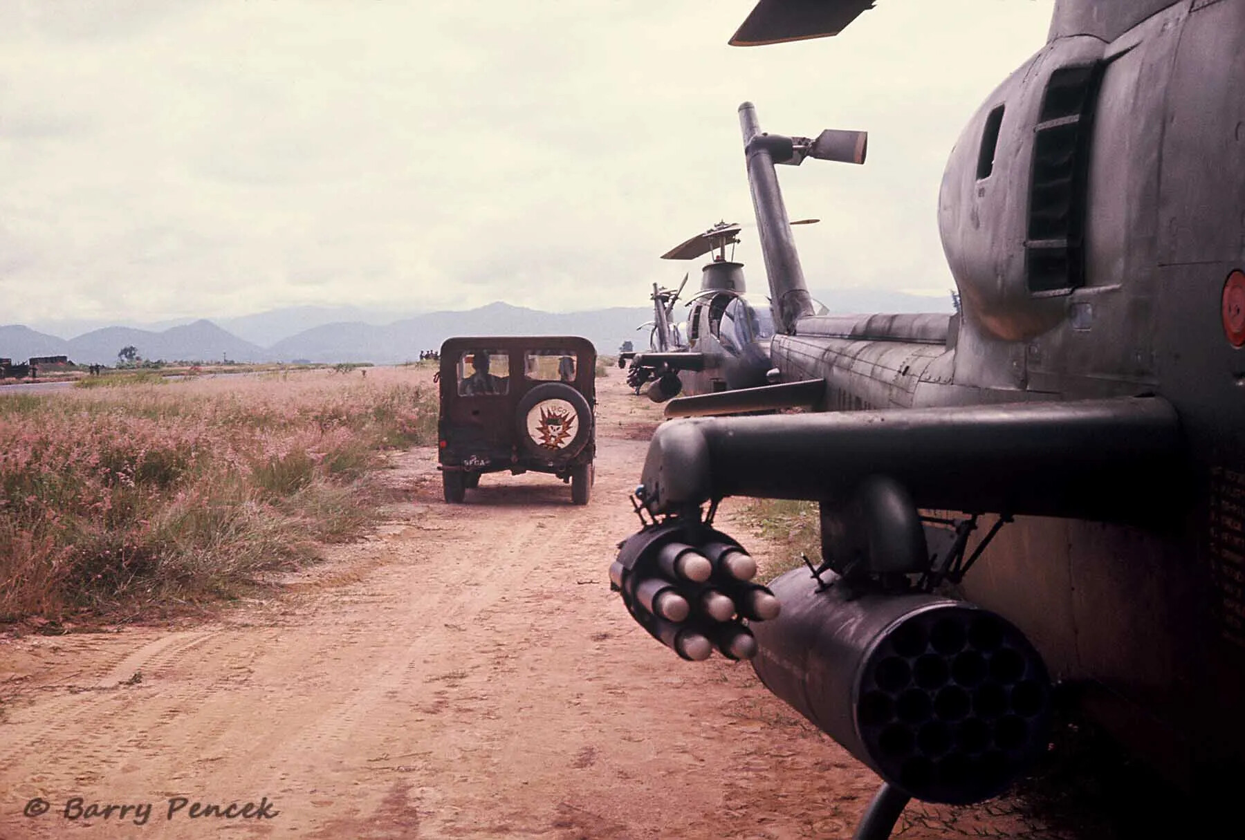 AH-1 Cobra Rocket Pods and Departing Jeep on Airstrip Access Road, South Vietnam
