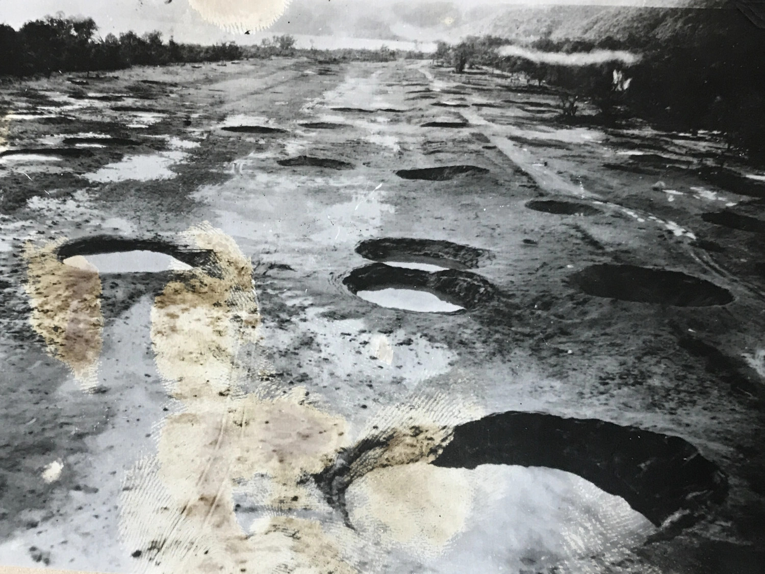 Ground-Level View of a Bomb-Cratered Airfield Runway