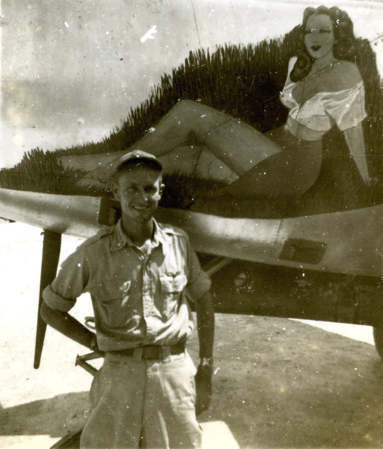Serviceman Posing with Camouflaged Aircraft and Pin-Up Nose Art, Ie Shima Area