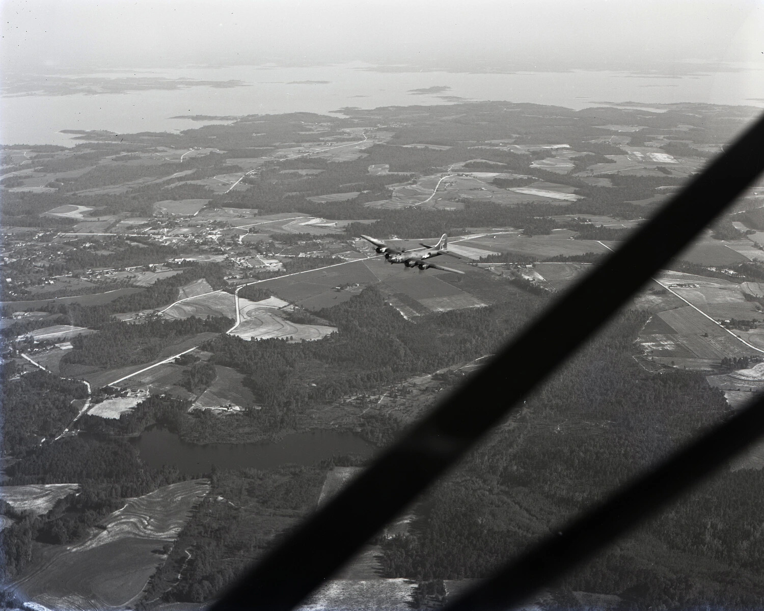 Air-to-Air Photograph of a B-17 Flying Fortress in Flight Over Farmland and Coastline