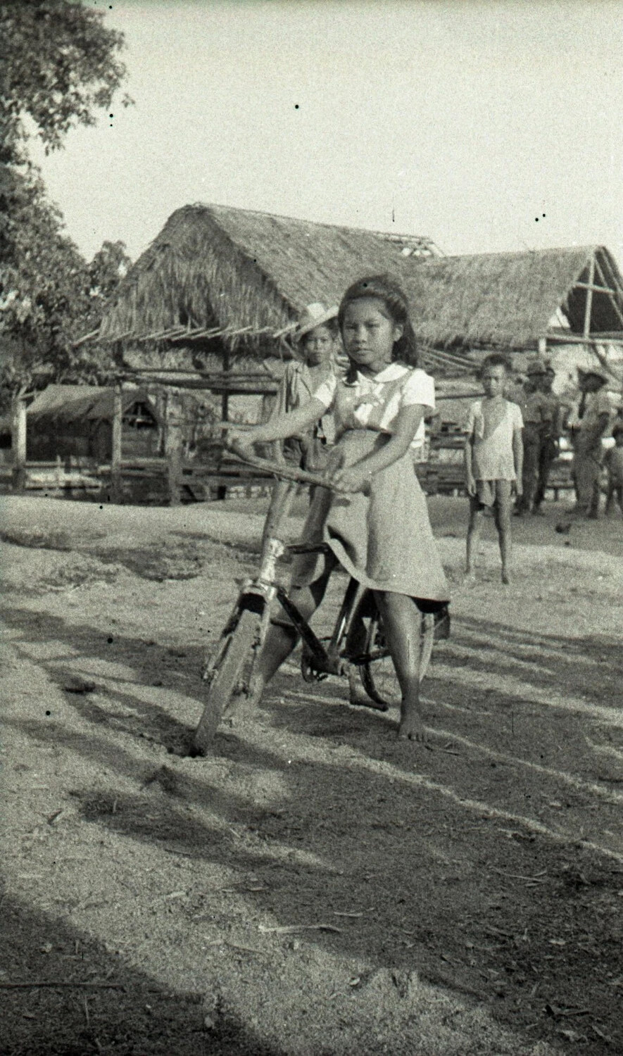 Filipino Girl on Bicycle in Village Yard, Luzon, Philippines, WWII Era