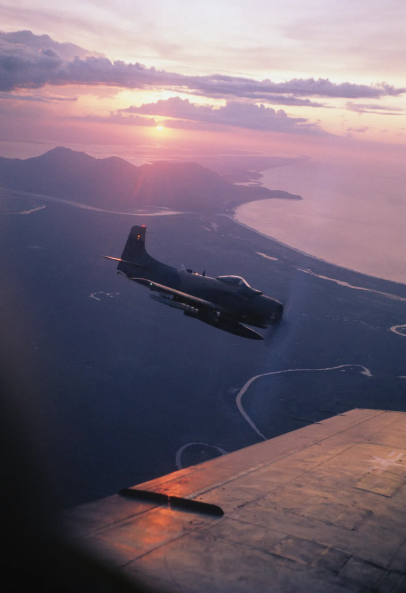 A-1 Skyraider Silhouetted at Sunset over Southeast Asian Coastline, Vietnam War