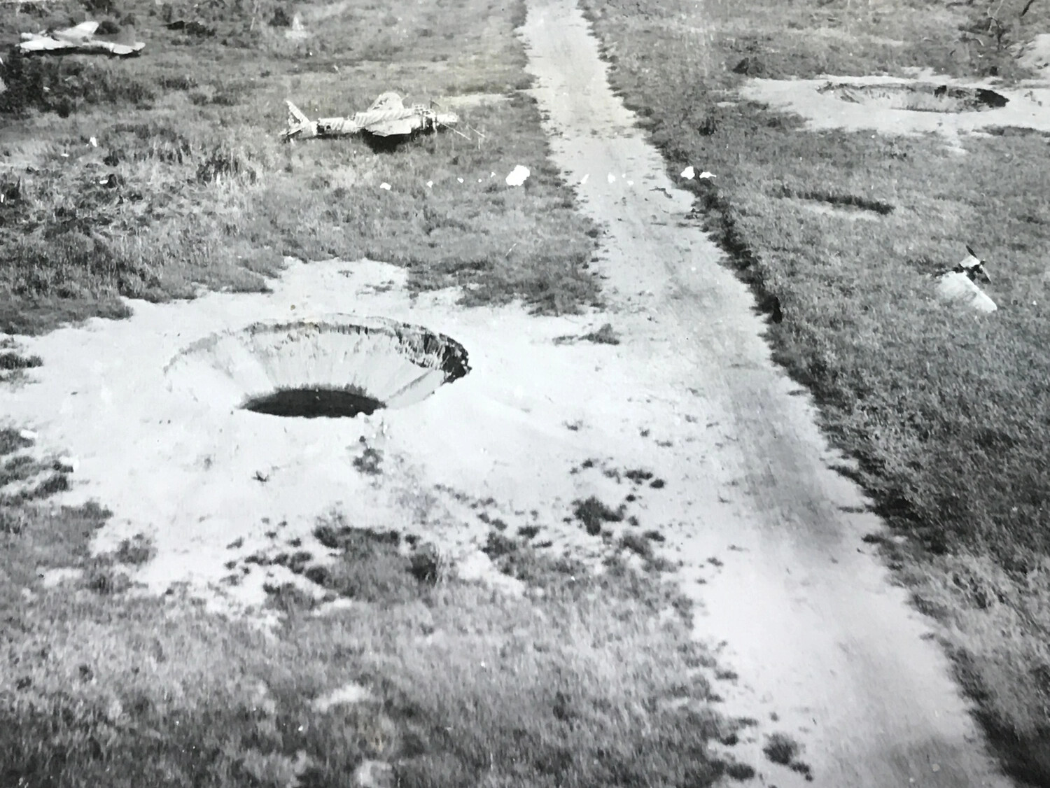 Bomb Crater and Wrecked Japanese Aircraft Beside Airstrip Road, Wewak Area, New Guinea