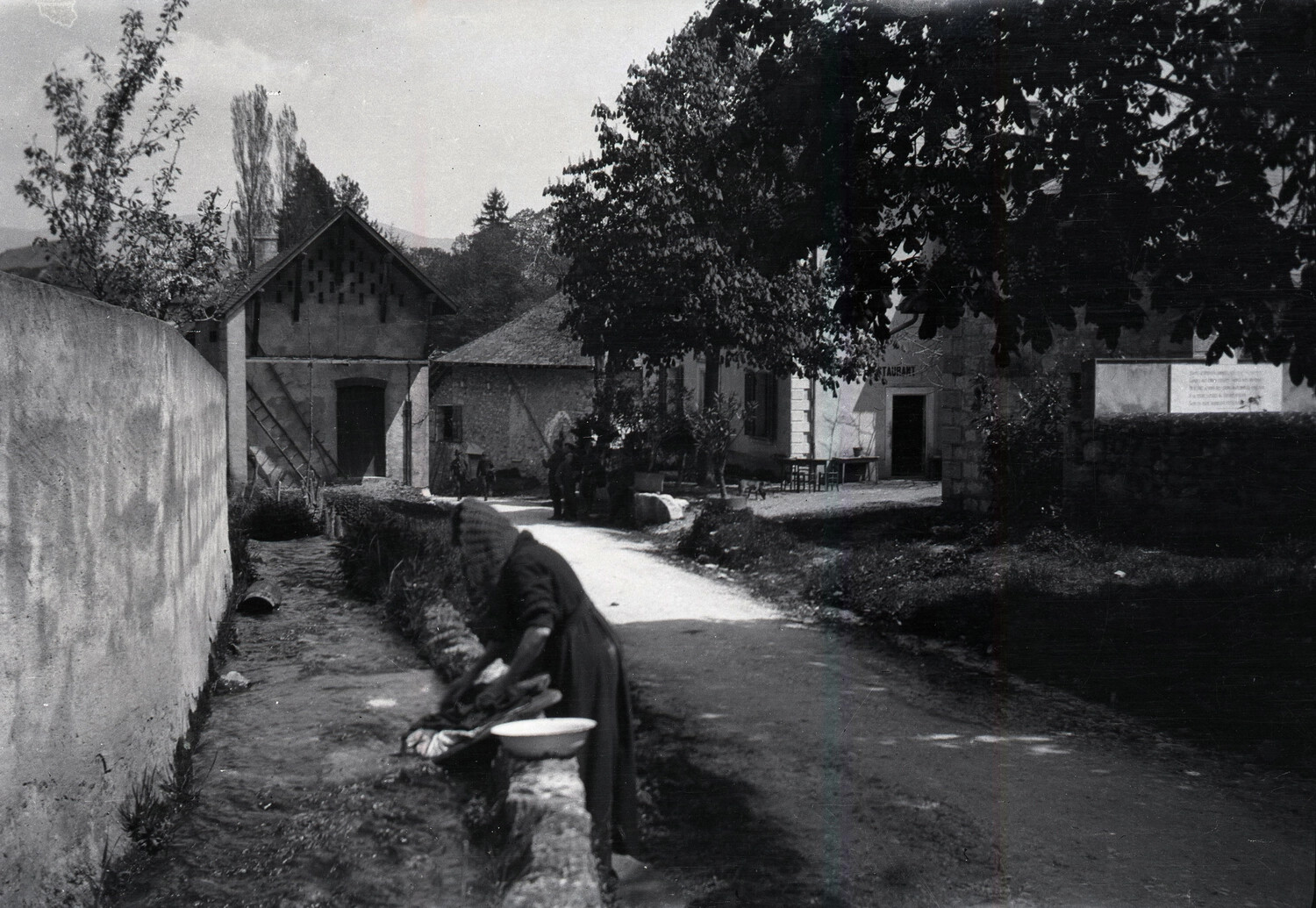 French Village Street Scene with Woman Washing Clothes, World War I Era