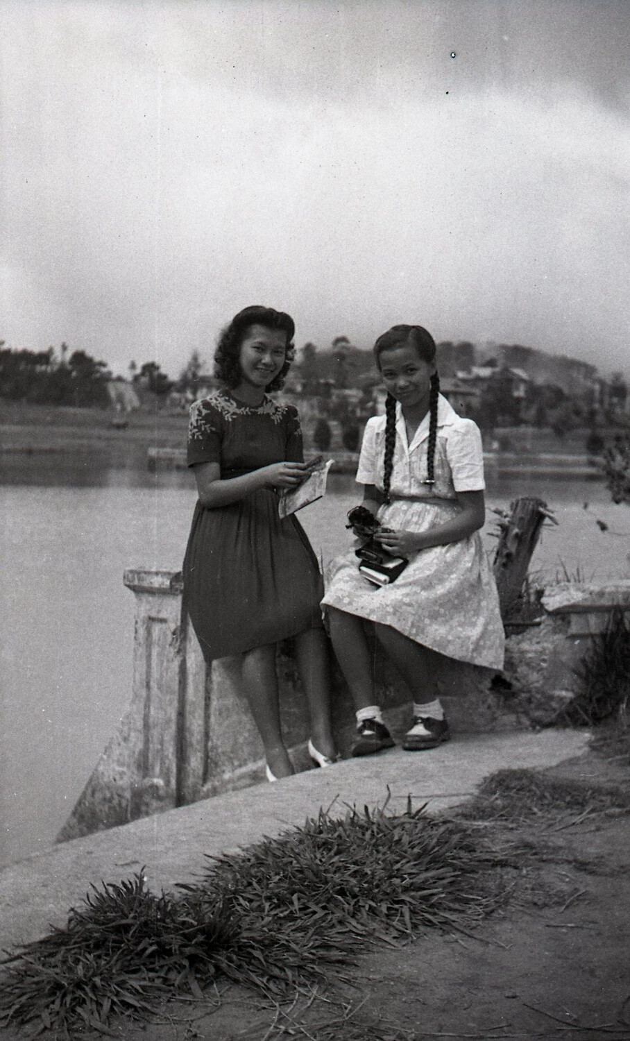 Two Young Women Posing by a Lakeside Balustrade, Luzon, Philippines, Mid-20th Century