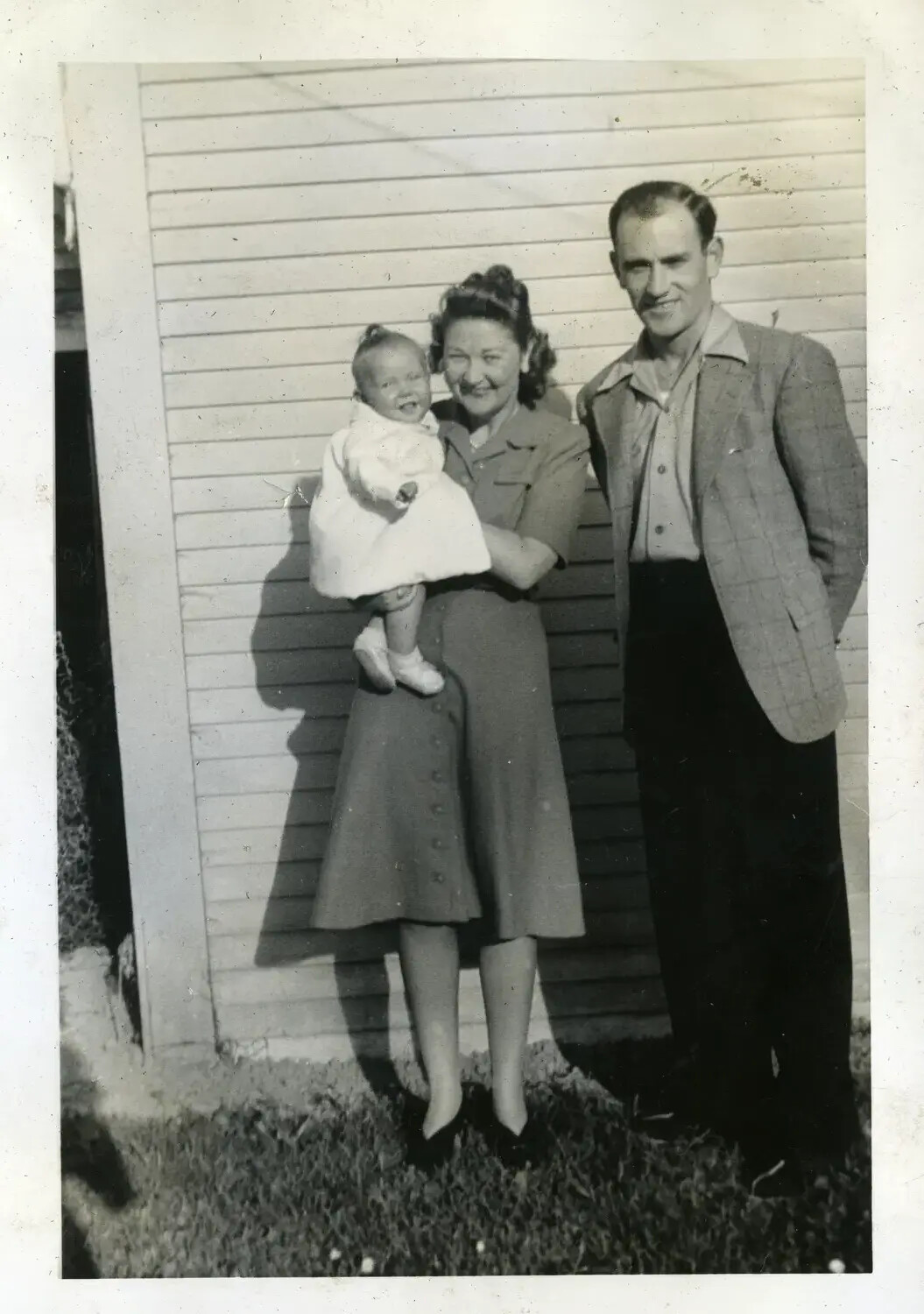 Family Portrait: Man, Woman, and Infant Outside Clapboard House, USS Maryland Album