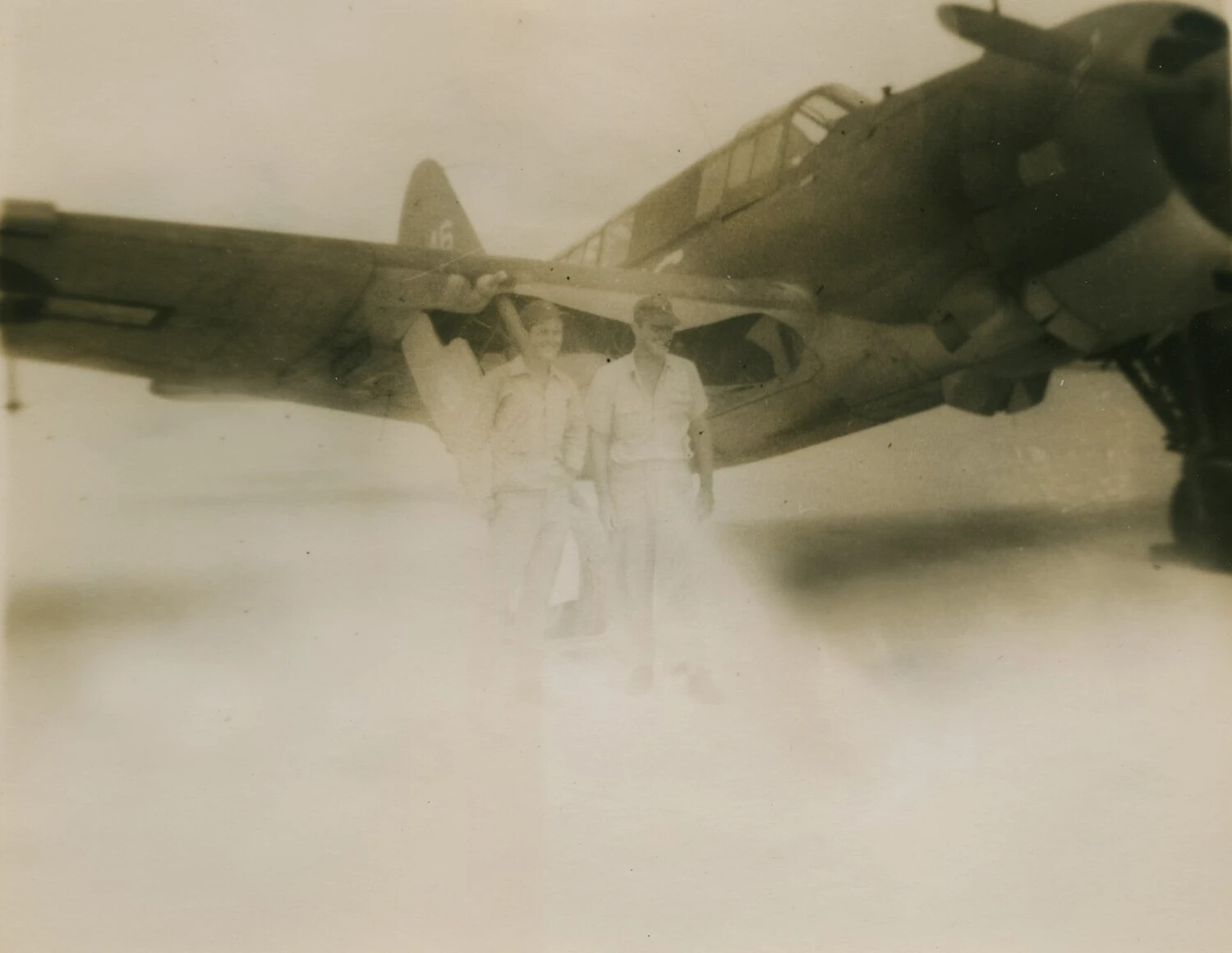 Two Servicemen Beneath Aircraft Wing (Faded Print), Pat McAleer WWII Photo Collection