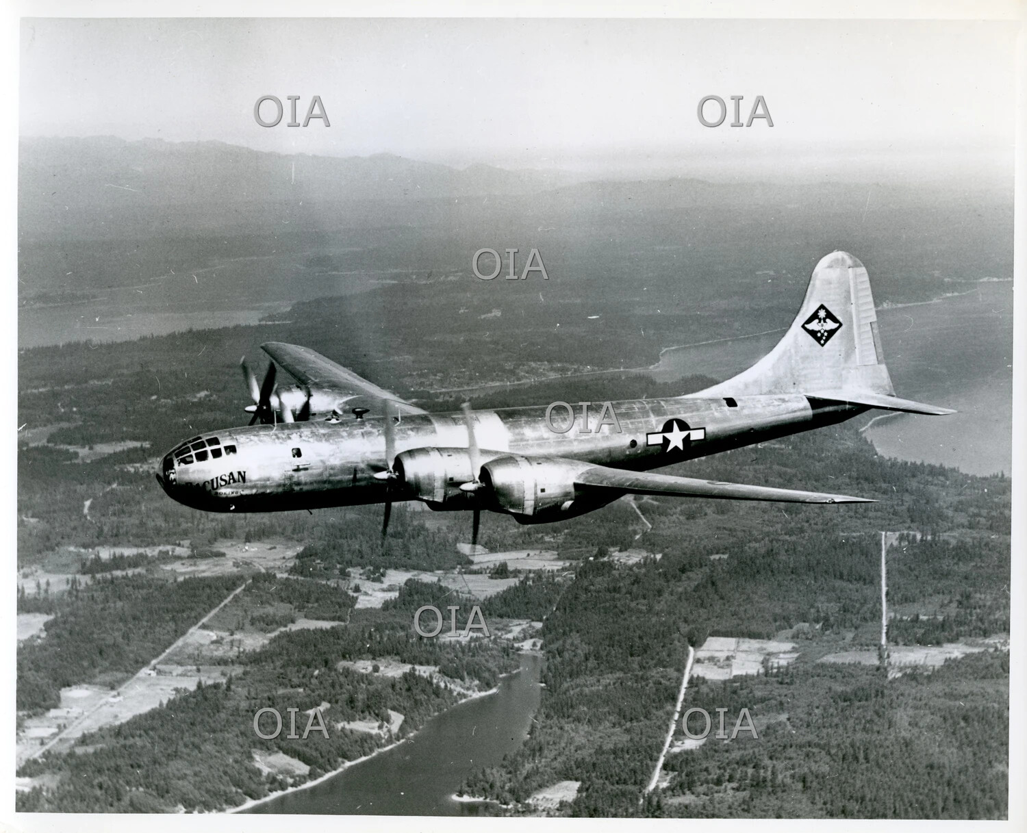 Boeing B-29 Superfortress in Flight, Nose Art '...ACUSAN', Aerial View Over Forested Valley