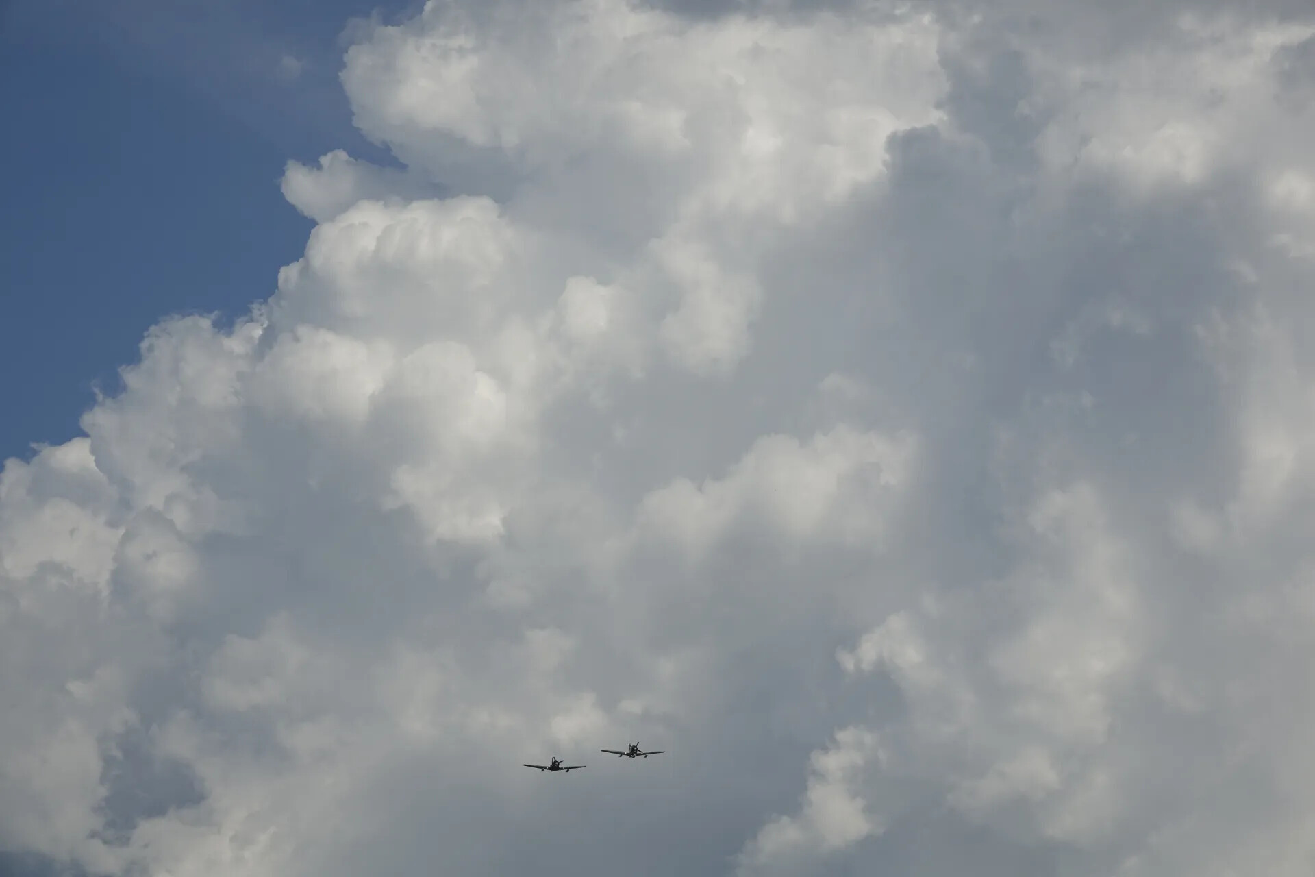 Two-Ship Warbird Formation Beneath Cumulus Clouds (Sequence Frame)