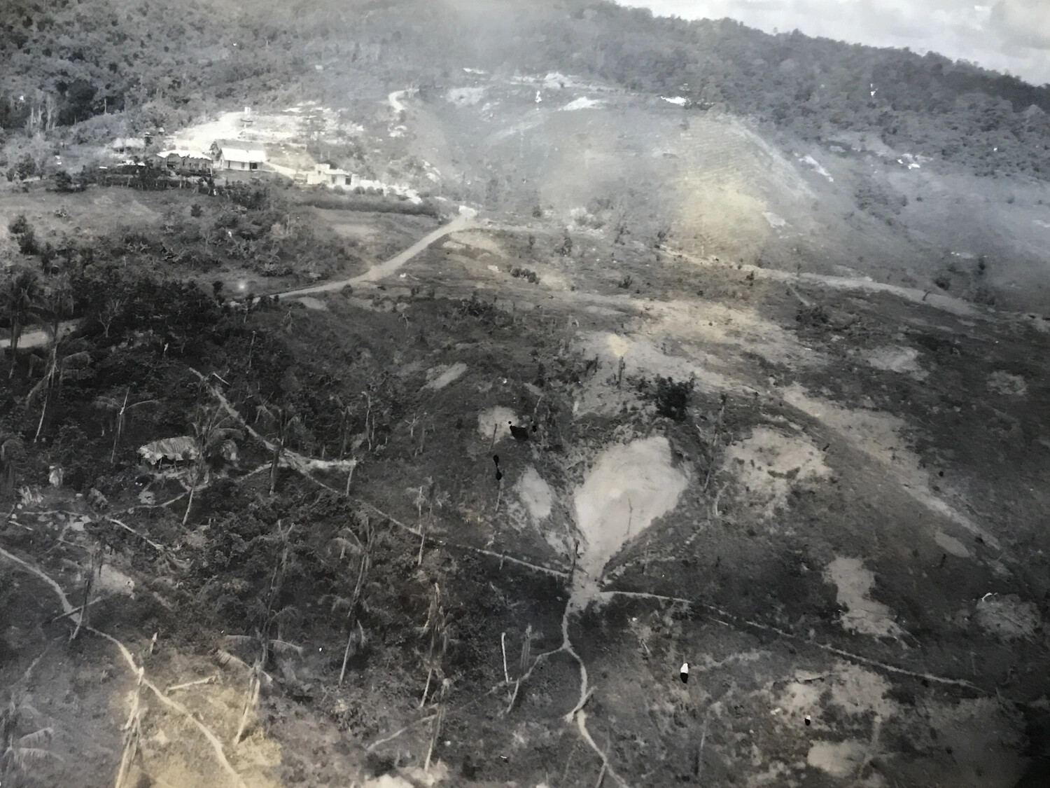 Low-Altitude Aerial View of a Plantation Building Complex and Cratered Terrain