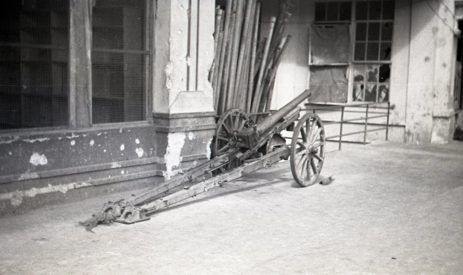 Abandoned Wheeled Field Gun Outside Damaged Building, Luzon, Philippines, 1945