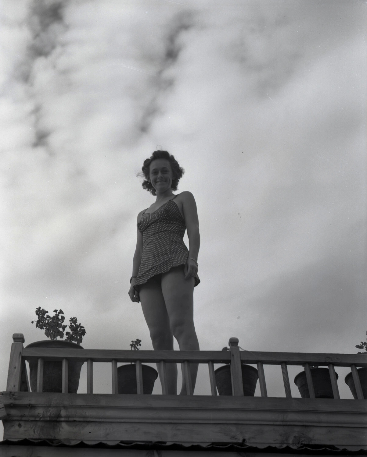 Woman in Polka-Dot Swimsuit on a Balcony Railing, Kashmir, WWII CBI Theater Collection