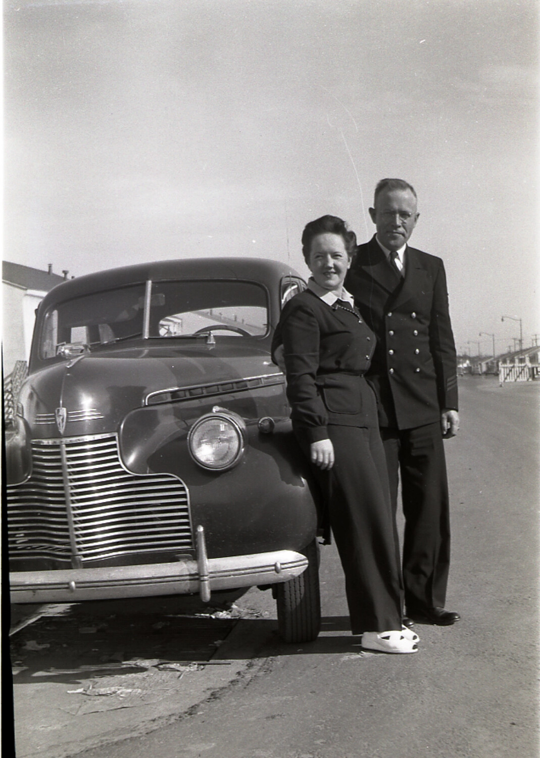 Navy Chief Petty Officer and Woman Beside a 1941 Chevrolet Sedan
