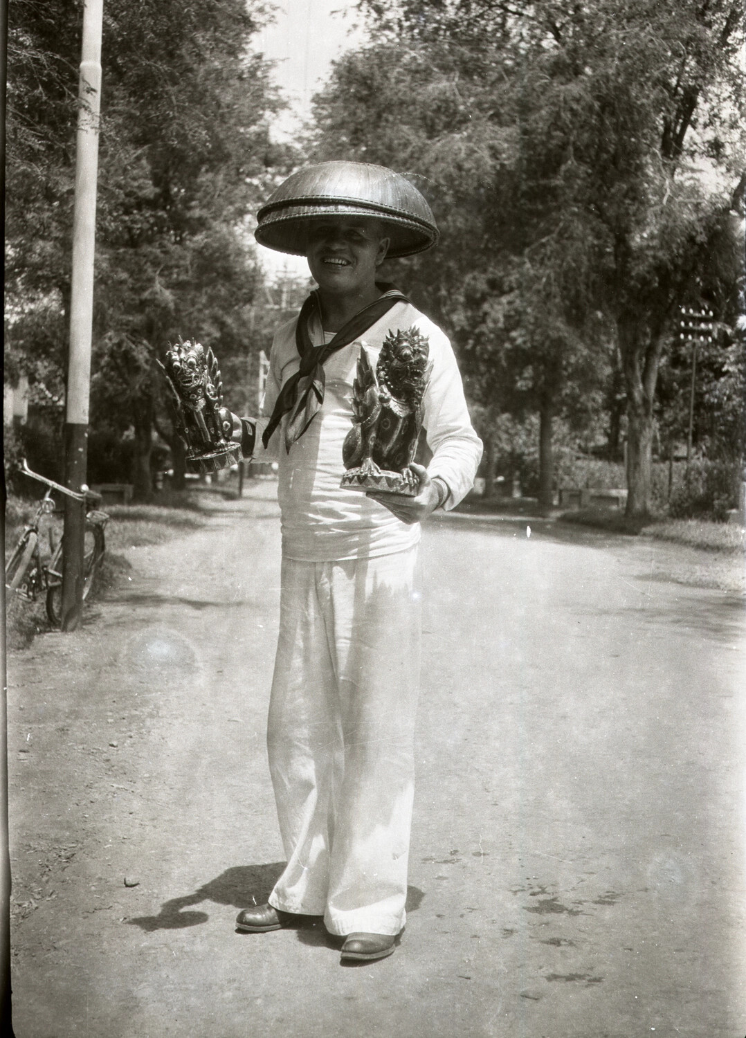 US Navy Sailor with Souvenir Statuettes and Chinese Hat, China, 1930s