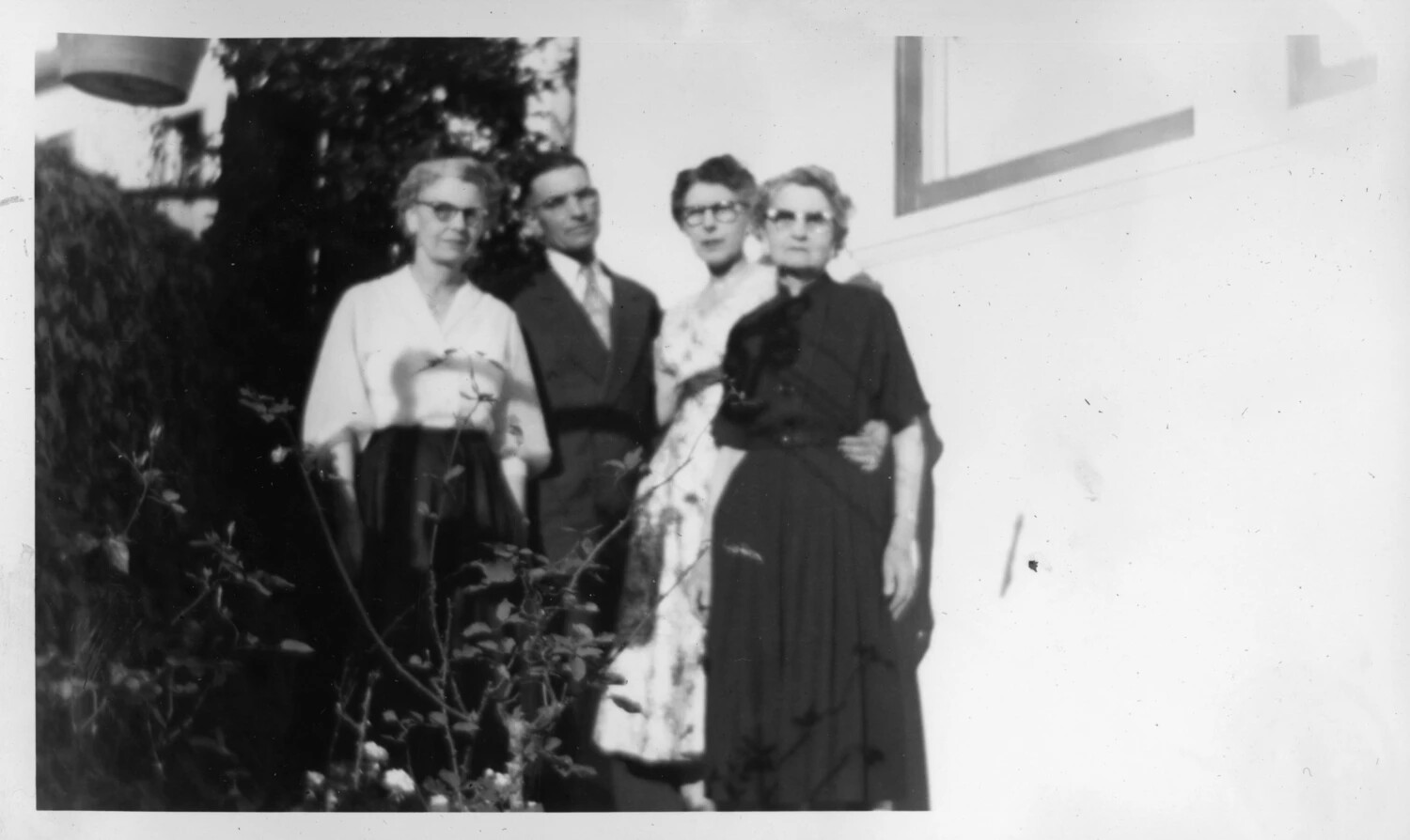 Group Portrait of Four Adults Outside Stucco Building, Presidio Photo Album