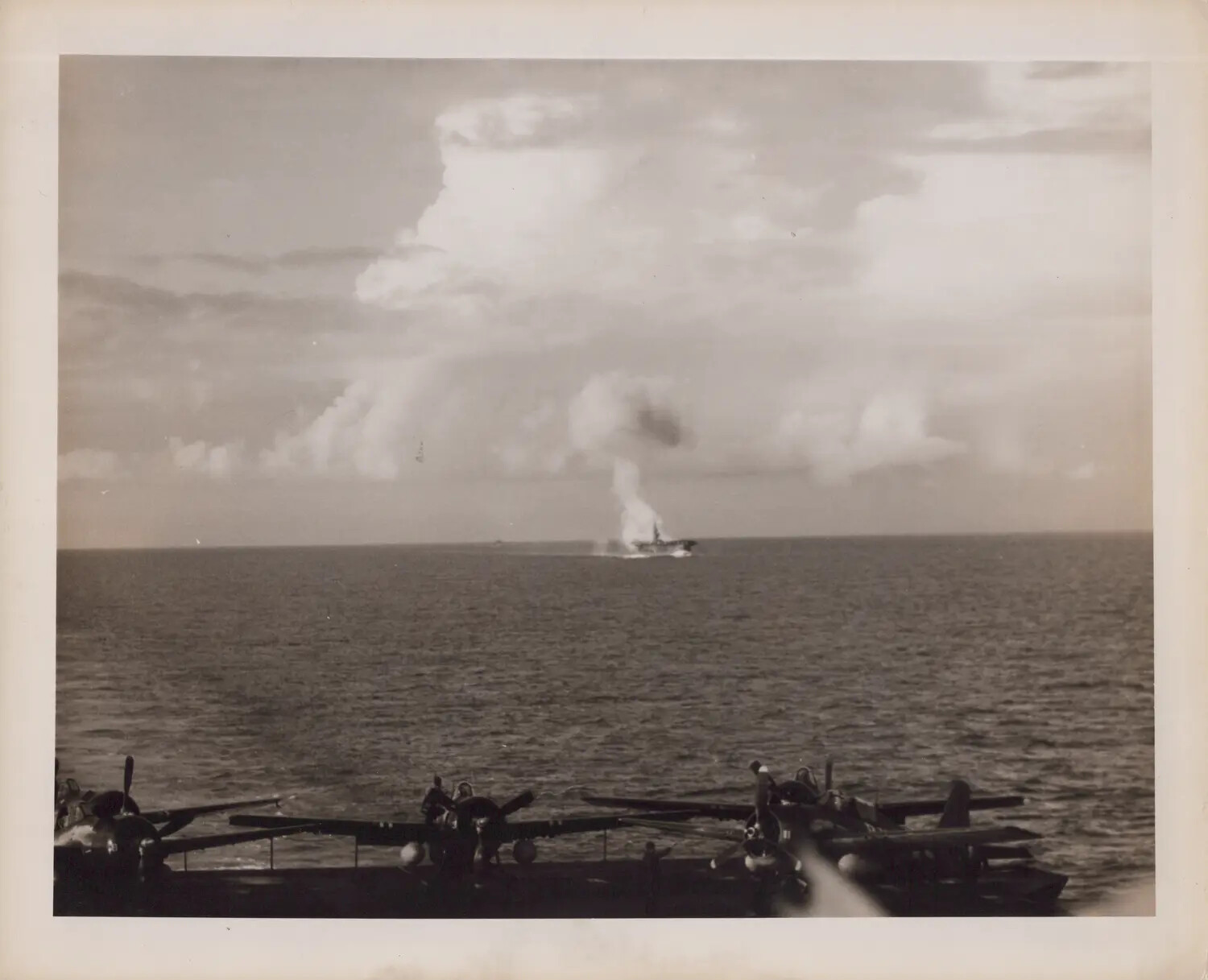 U.S. Navy Carrier Flight Deck with Parked Torpedo Bombers and Distant Warship Smoke Column, WWII Pacific Theater