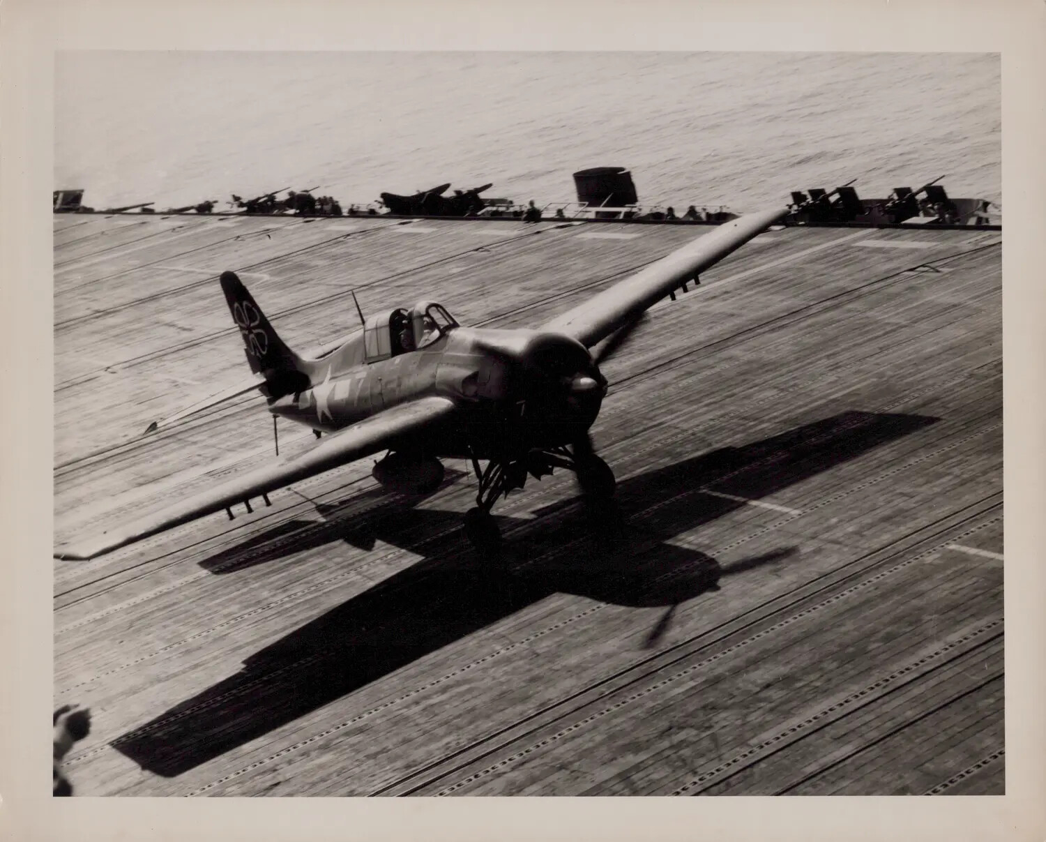 Carrier Fighter Banking Low Over the Flight Deck of U.S.S. Petrof Bay (CVE-80) at Takeoff, April 16, 1945