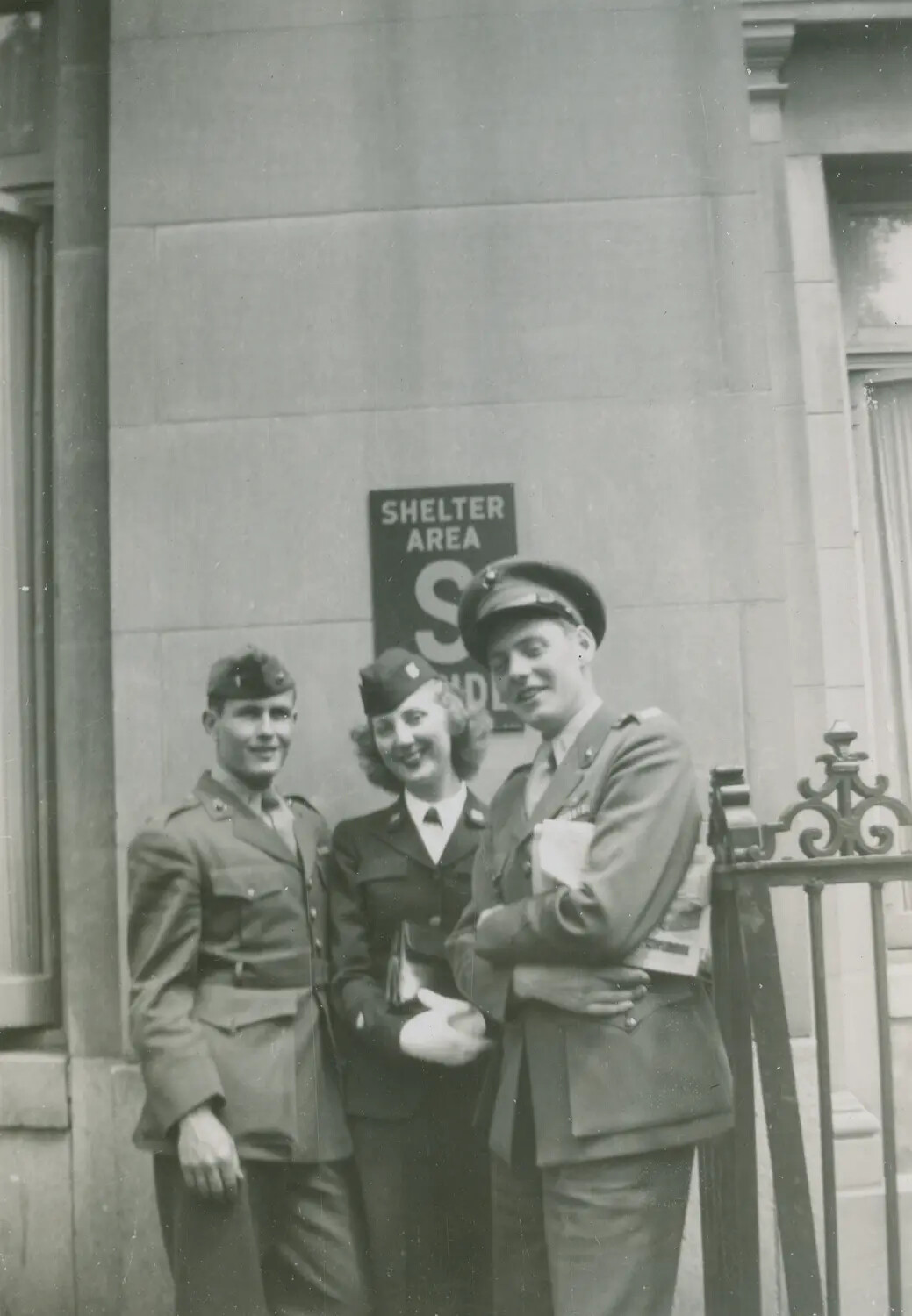 Three Servicemembers Outside Building with 'Shelter Area' Sign, WWII England (McAleer Collection)
