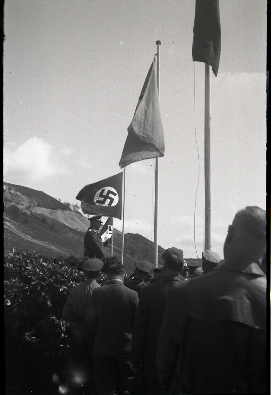 Uniformed Official Addressing a Crowd Beneath Nazi Party Flags, German Hillside Event, 1930s