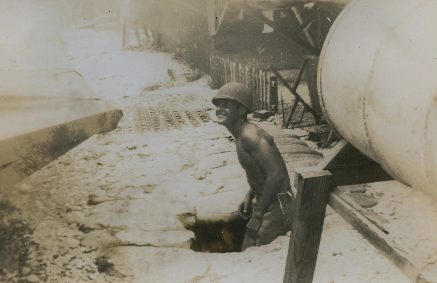 Serviceman in Foxhole Beside Sandbagged Fuel Storage — Pacific Theater, WWII