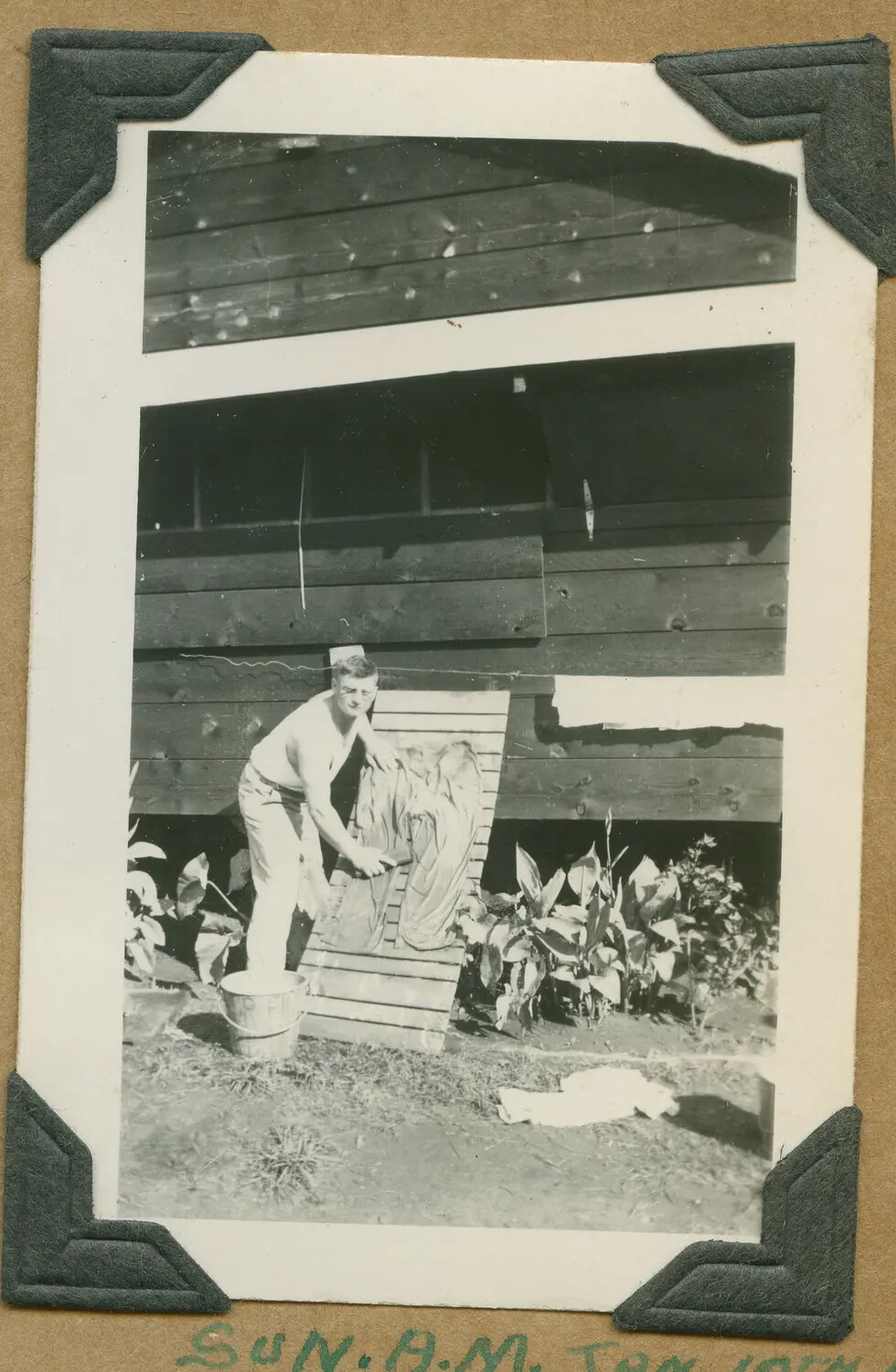 Serviceman Hand-Washing Laundry Outside Barracks Building, Hawaii, WWII Era