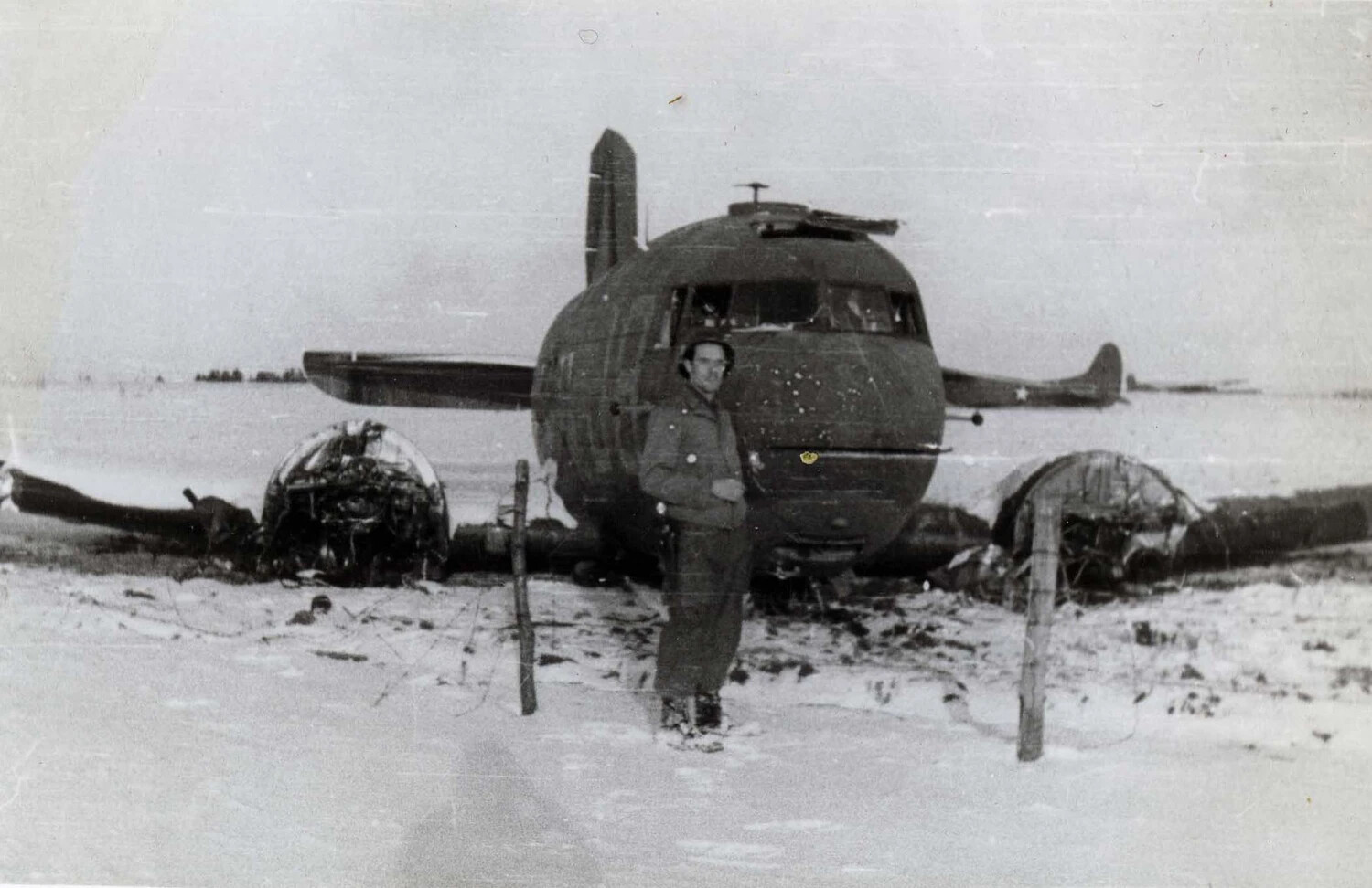 Wrecked Twin-Engine Bomber 'Ain't Missbehavin'' with Soldier Posing, Snow-Covered Field, WWII