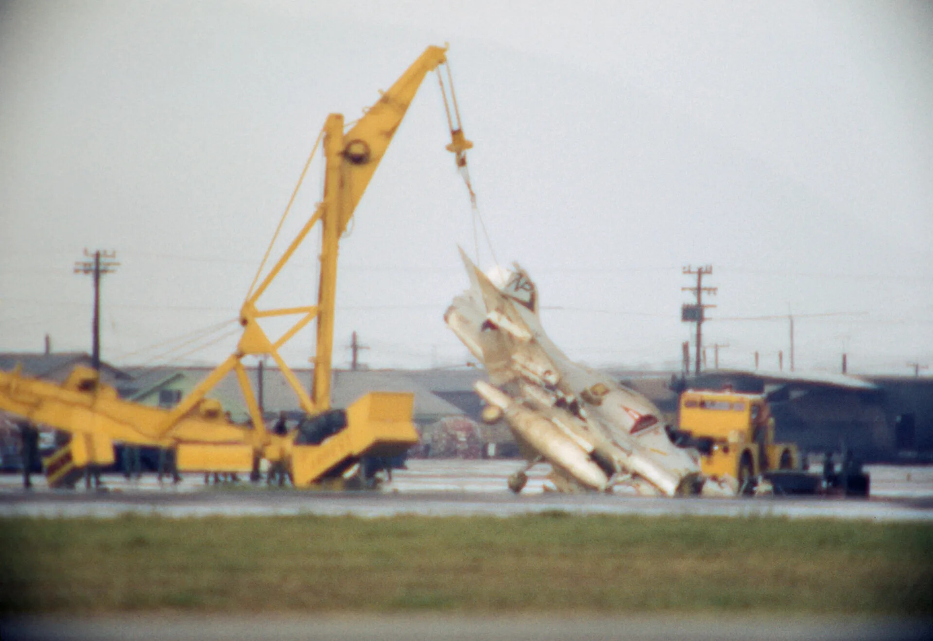 Crash Recovery Operation: Jet Aircraft Wreckage Lifted by Mobile Crane, Vietnam-Era Air Base