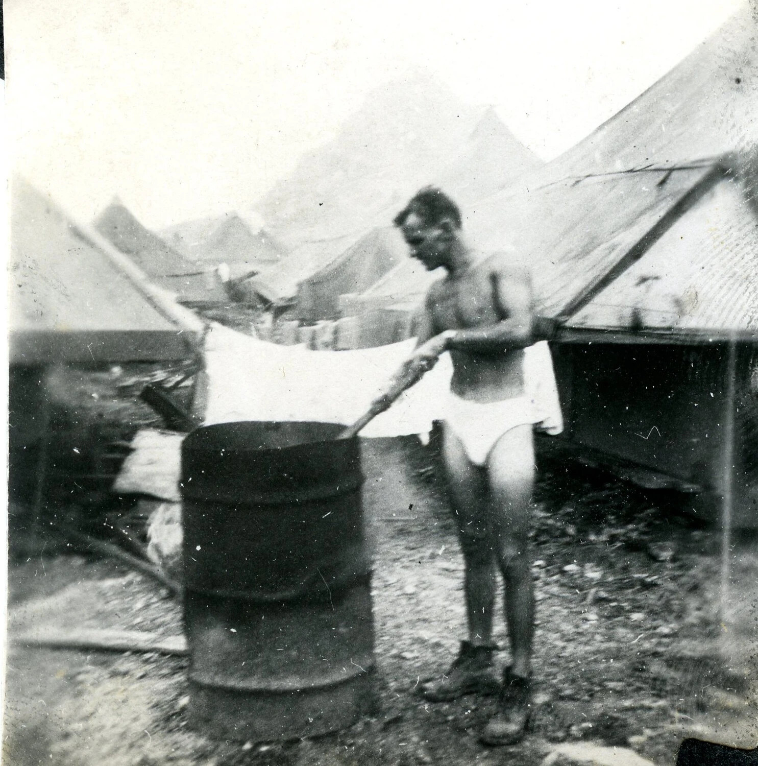 Serviceman Doing Laundry in Improvised Drum 'Wash Trough' — 345th Bombardment Group Encampment, Ie Shima, WWII