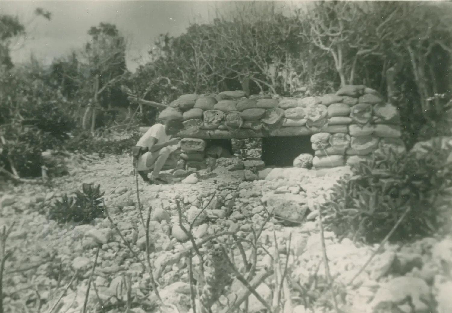 Serviceman Examining Sandbag Bunker Fortification, Pacific Island - McAleer Collection