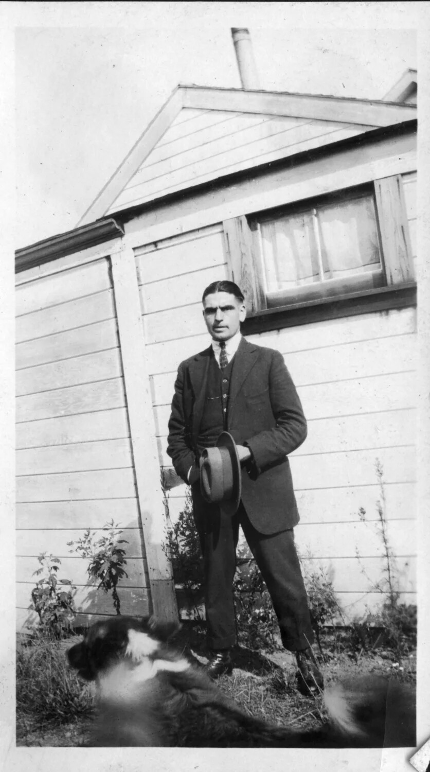 Portrait of a Young Man in Suit with Dog Beside a Frame Outbuilding, Presidio Family Album, c. 1910s-1920s