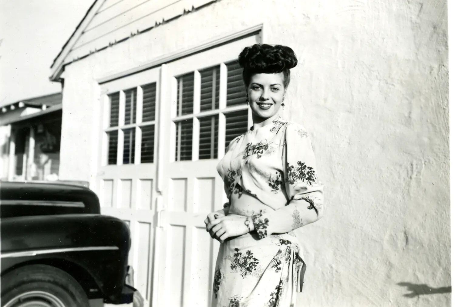 Portrait of a Young Woman in Printed Dress Outside Stucco Residence, 1940s (Likely Misfiled Home-Front Photograph)