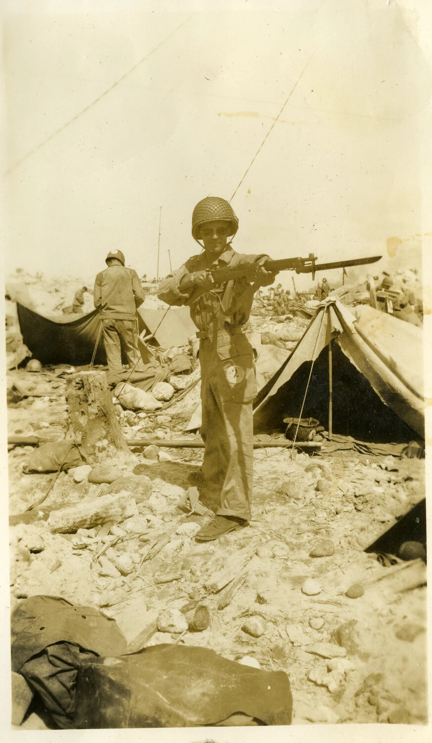 U.S. Serviceman Posing with Fixed-Bayonet Rifle Amid Rubble, Kwajalein Atoll, WWII