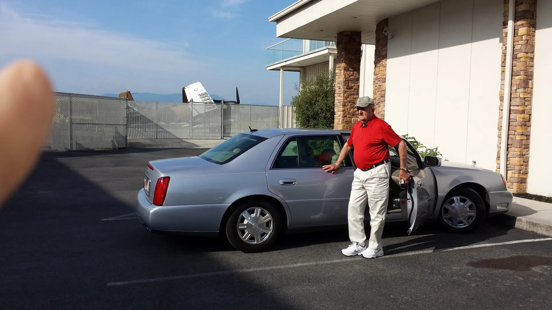 Visitor Beside Parked Cadillac Outside Air Museum Facility