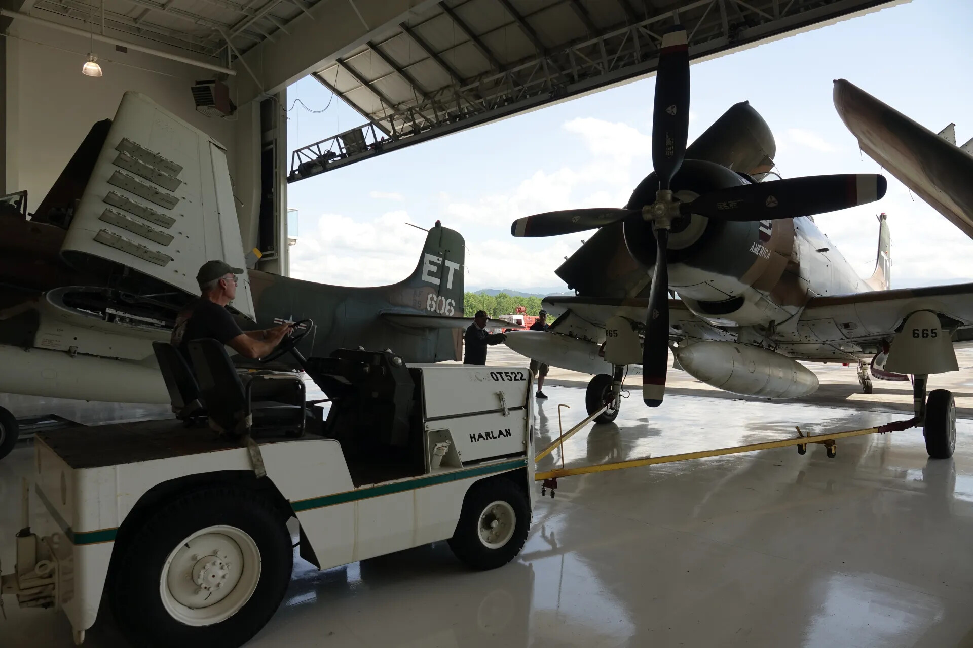 Ground Crew Towing A-1 Skyraider 'ET/606' from Hangar Past Skyraider 'America 665' (Alternate Frame)