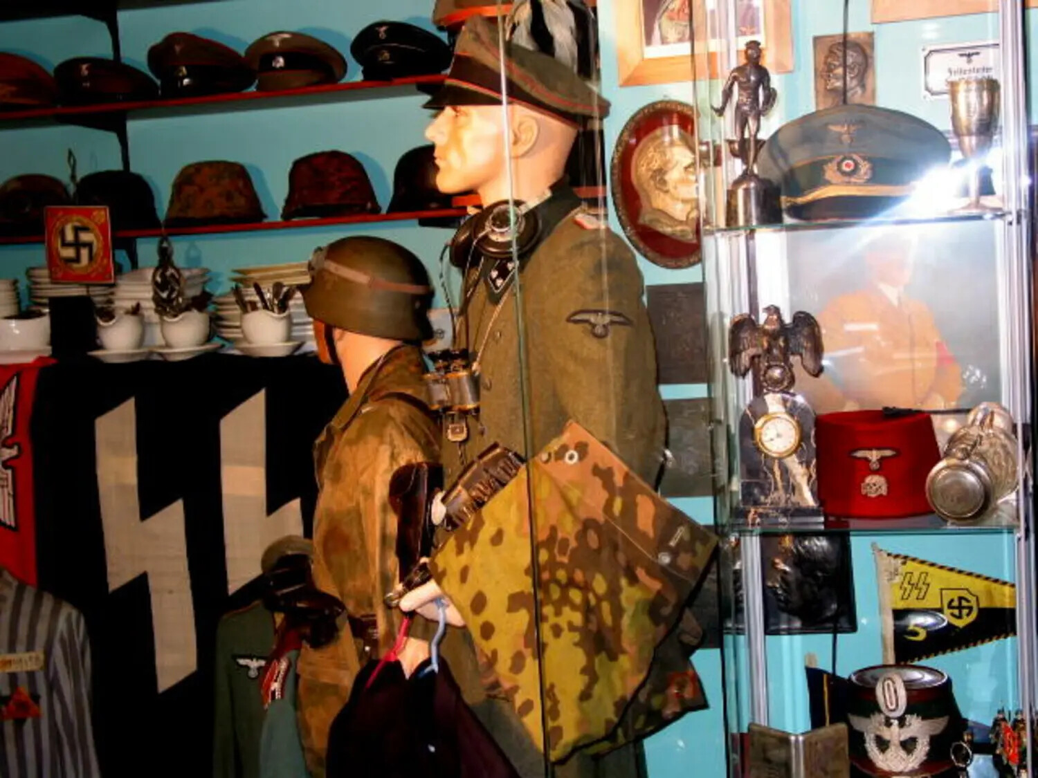 Corner Display of German WWII Militaria with Glass Cabinet of SS Insignia and Trophies