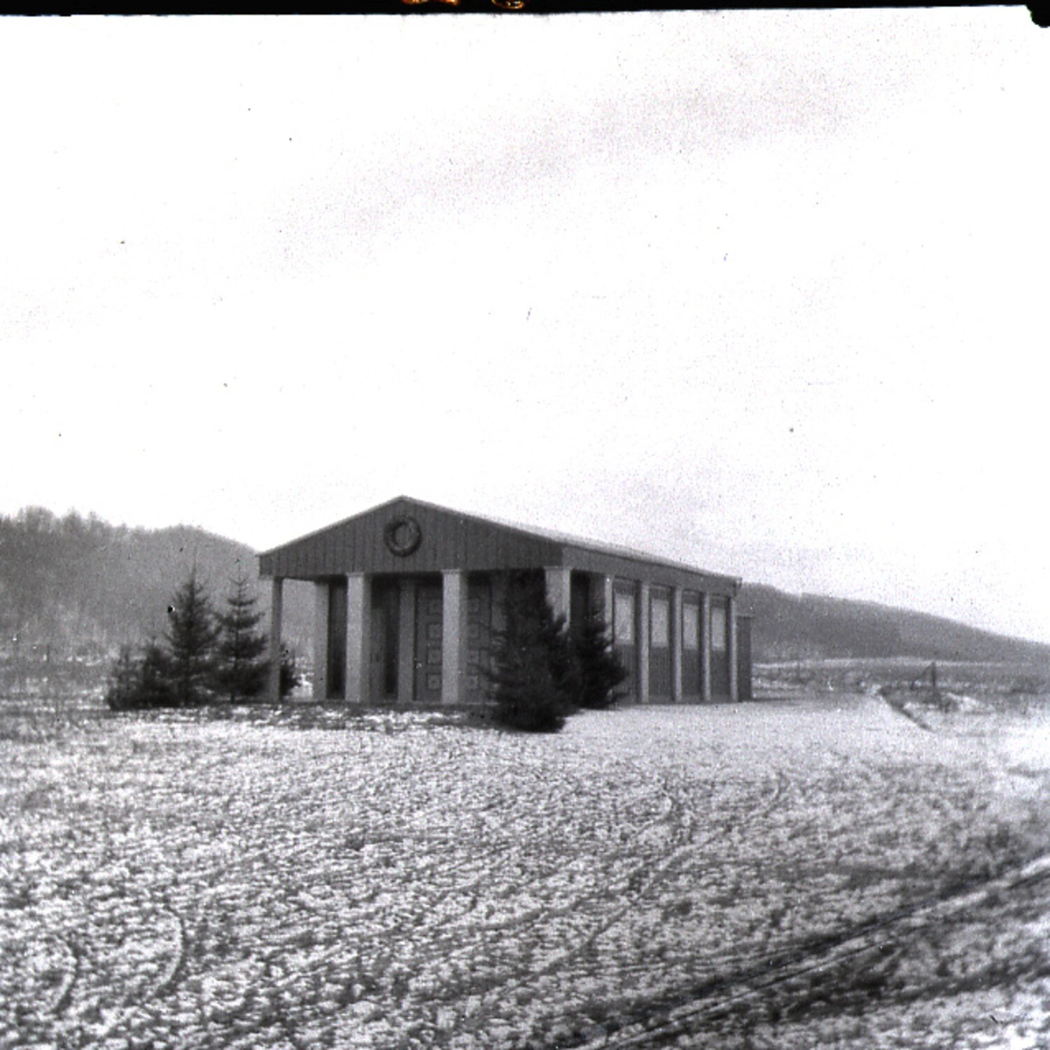 Modern Single-Story Building with Gabled Portico in a Snow-Covered Field (Later-Era Structure, Misfiled/Associated with WWI-Themed Collection)