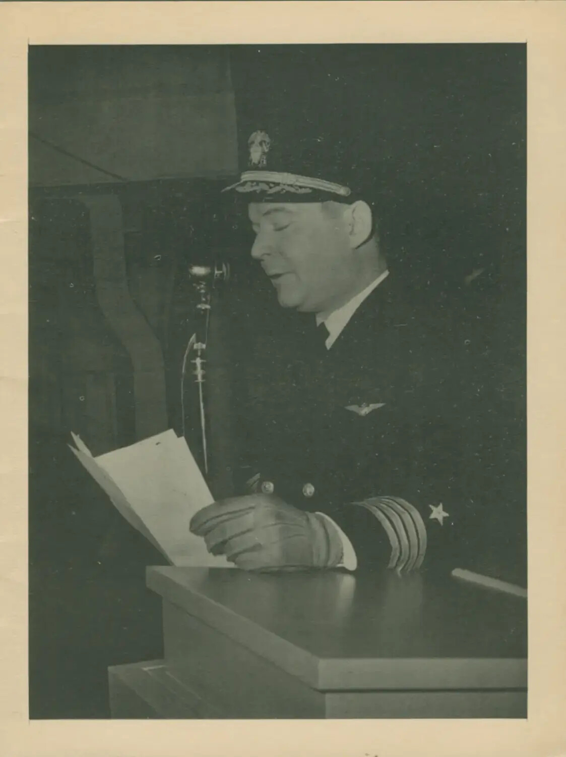U.S. Navy Captain Addressing Crew from Podium Aboard USS Petrof Bay (CVE-80), WWII Era