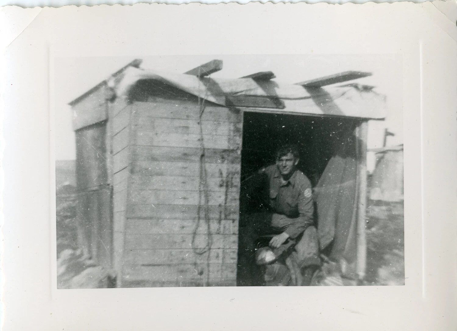 Serviceman at Entrance of Improvised Wooden Shelter, Pacific Theater, World War II Era