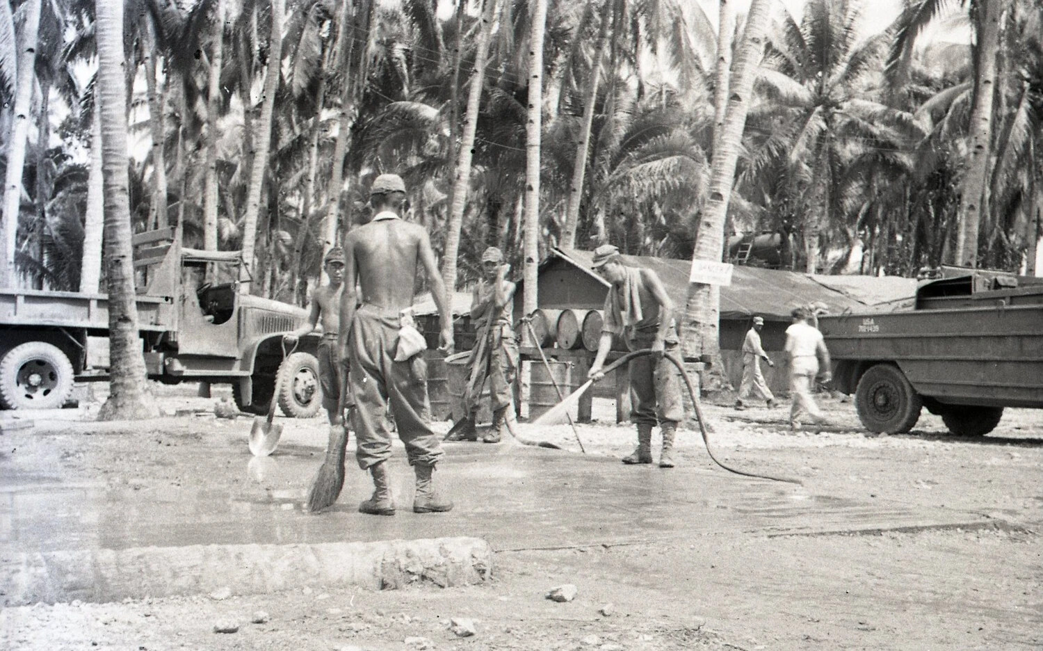 Servicemen Finishing Concrete Pad with Military Vehicles and Danger Sign, Luzon, Philippines, WWII