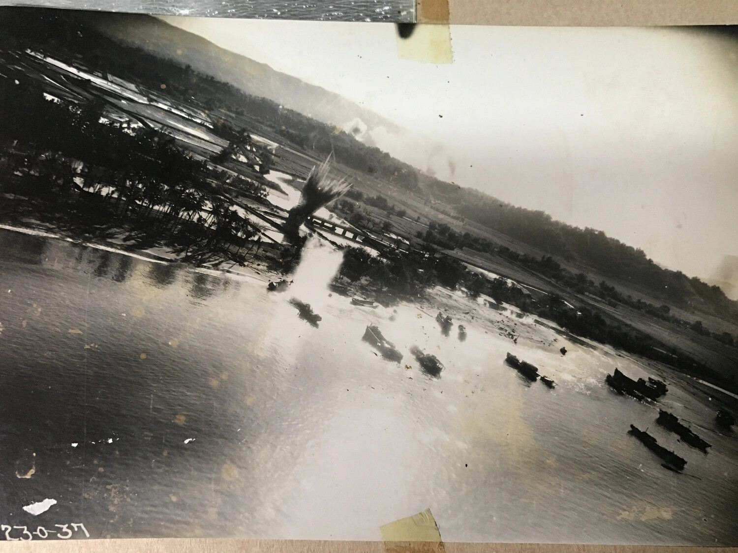 Aerial Strike Photograph: Bomb Burst Near River Mouth with Moored Barges, Pacific Theater, WWII