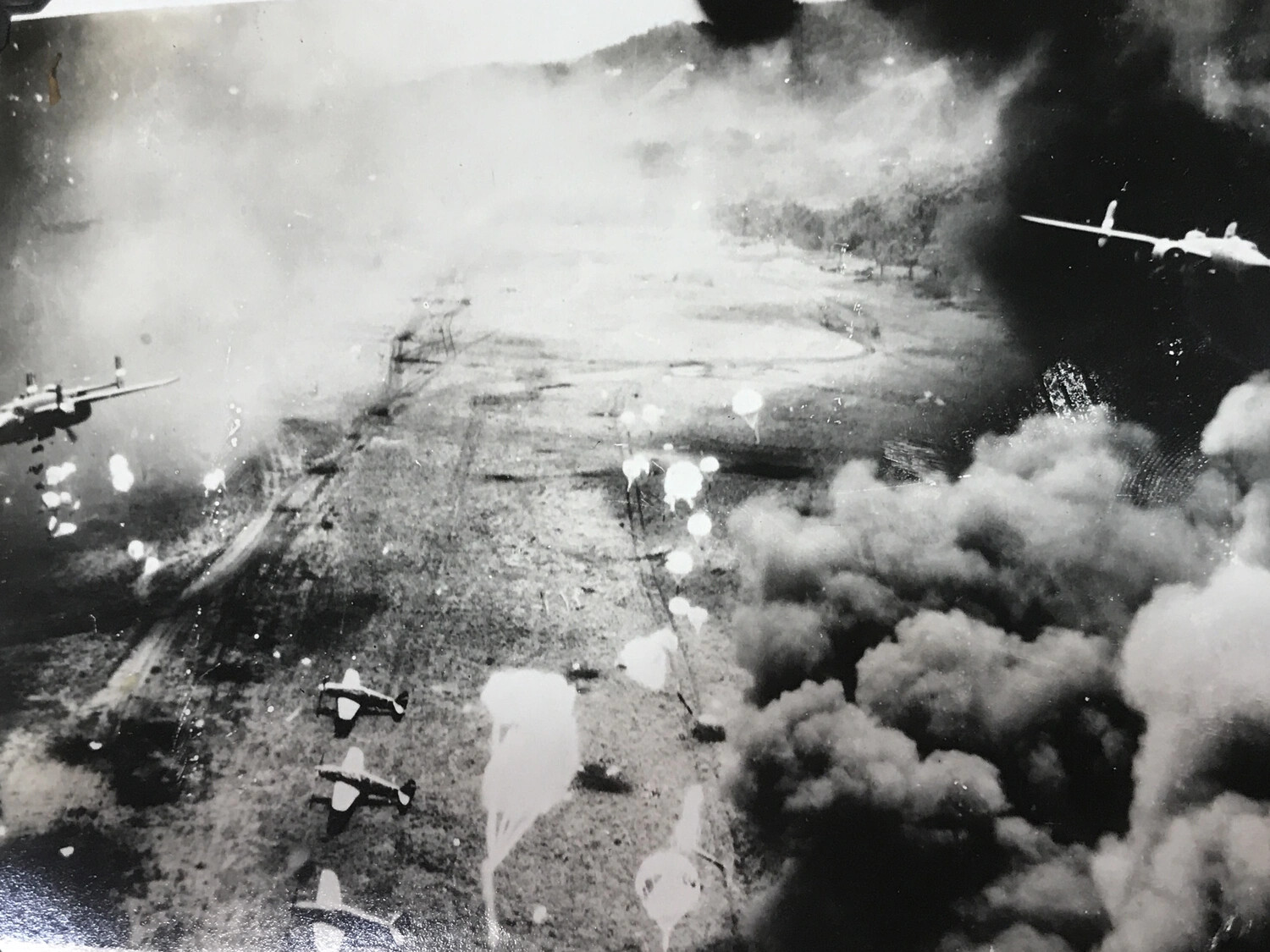 Low-Altitude Strike Photograph: B-25 Mitchells Amid Smoke and Parachute-Retarded Bombs, Dagua Airfield
