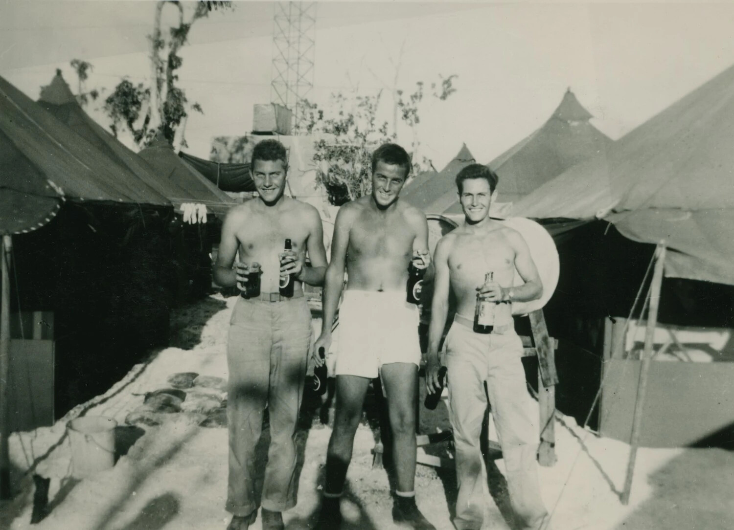 Three Servicemen with Beer Bottles at Tent Camp, WWII Pacific Theater