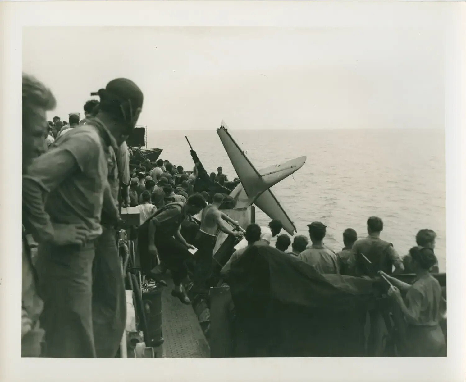 USS Petrof Bay (CVE-80) Crew Jettisoning Wrecked Aircraft Tail Section Overboard