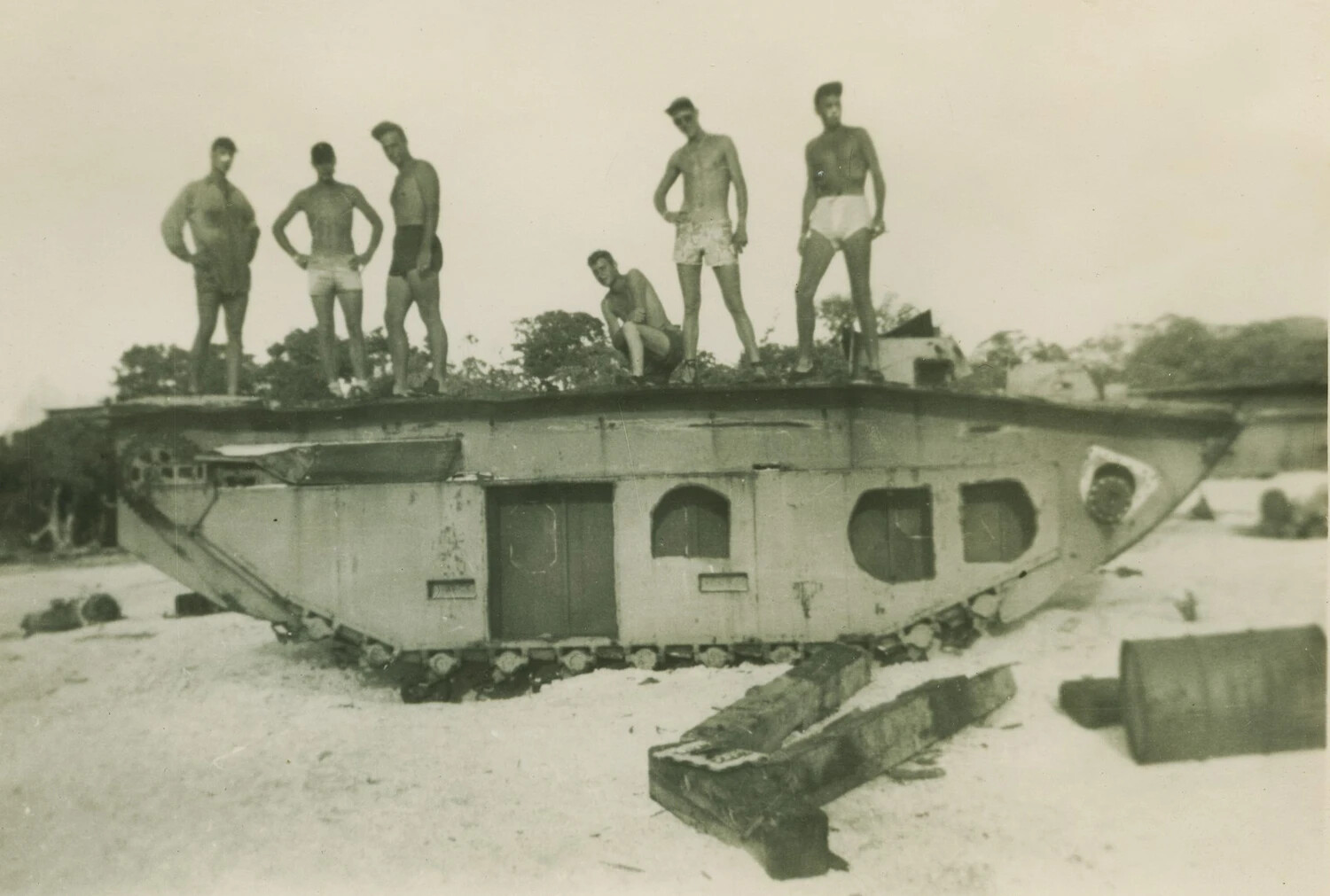 Servicemen Posing atop Derelict Tank Hull Converted to Beach Shelter, Pacific Theater, WWII