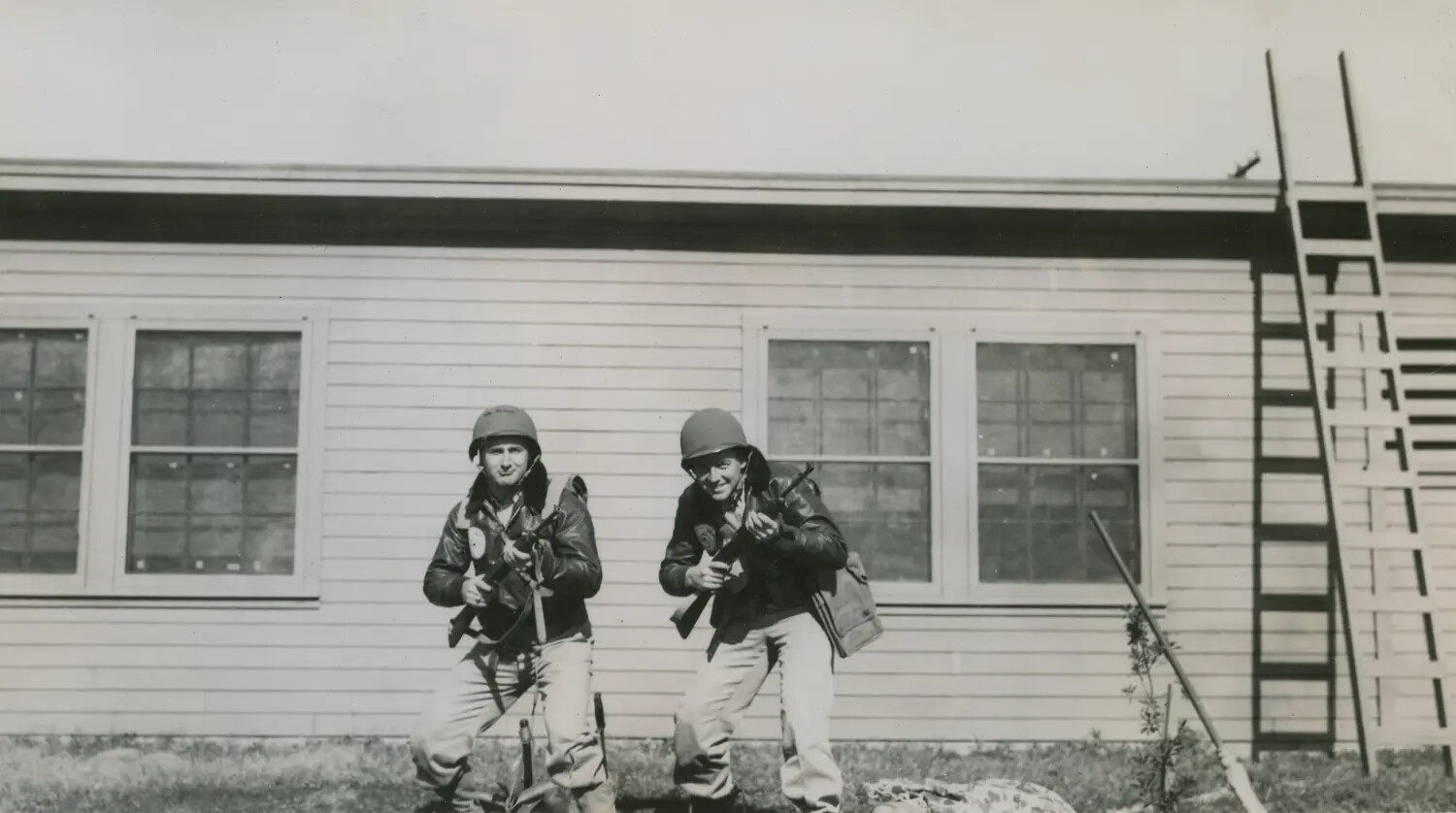 Two Airmen Posing with Firearms in Front of Barracks, Edward P. McAleer Collection, WWII