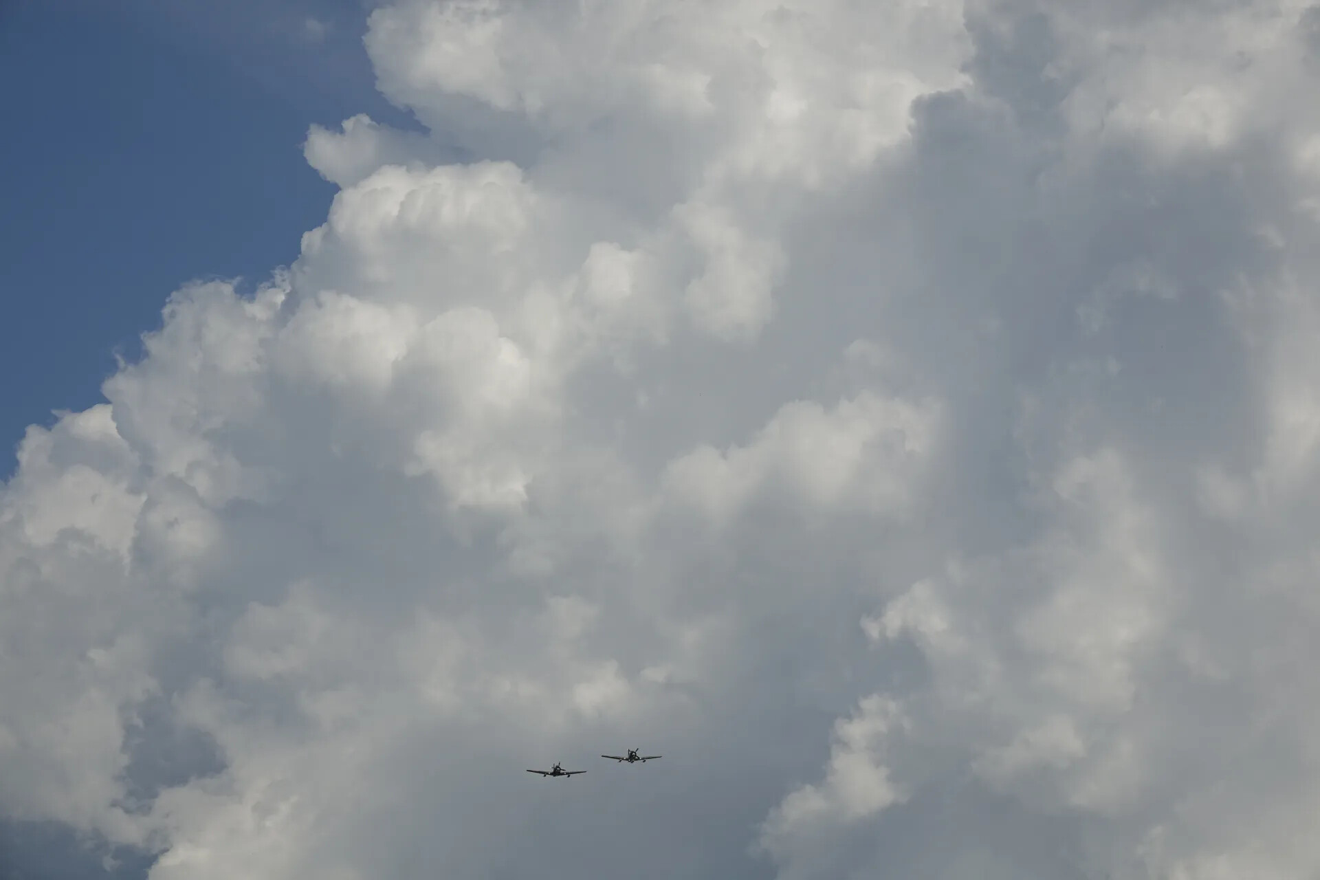 Two-Ship Warbird Formation Beneath Cumulus Clouds (Sequence Frame)